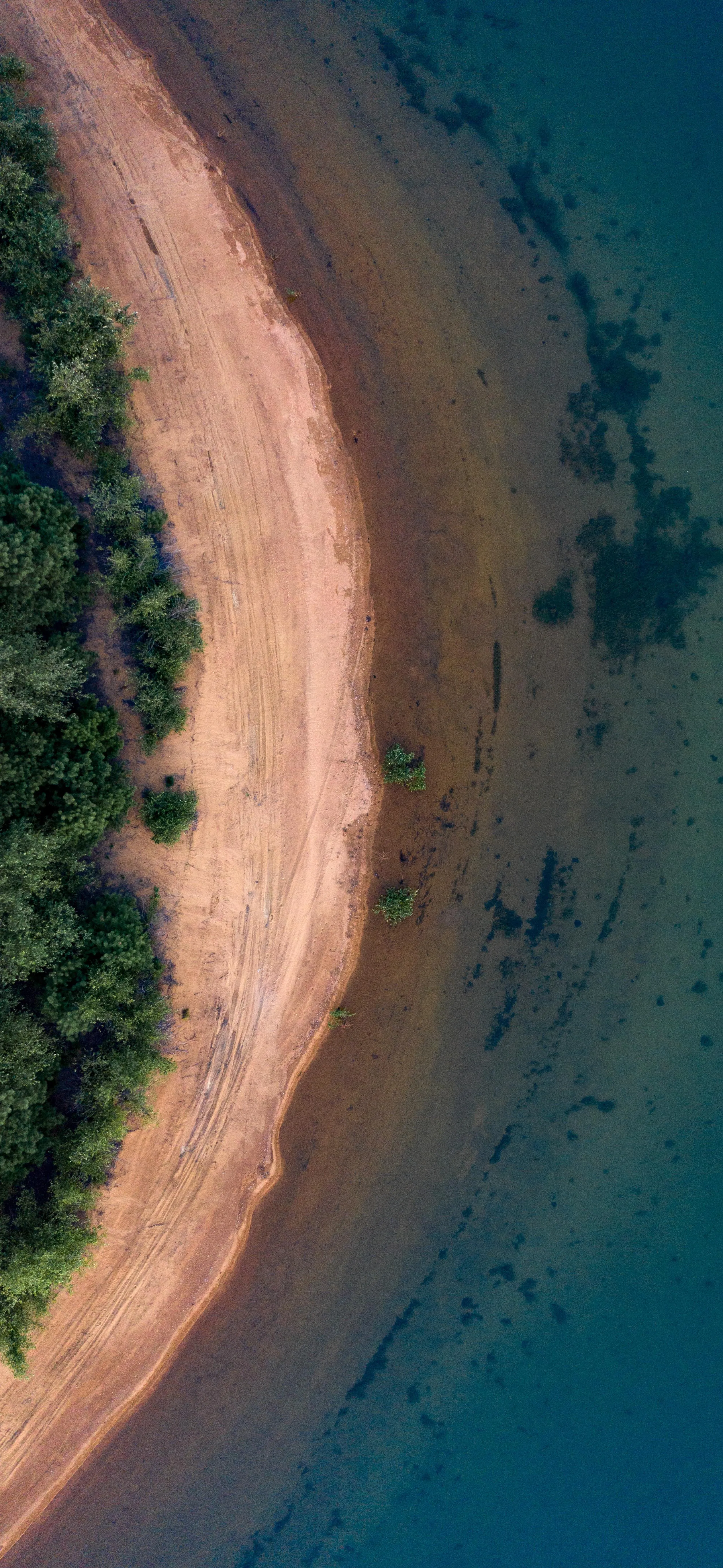 Aerial View of Beach with Blue Water and Red Sand Wallpaper