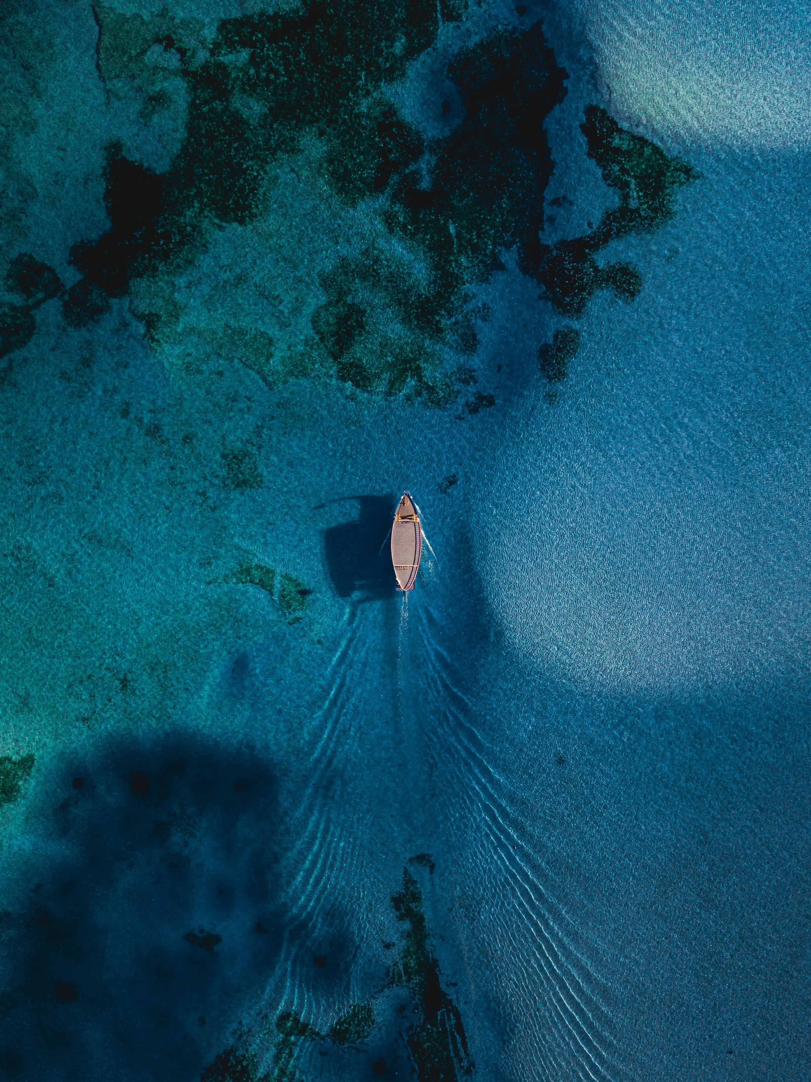 Aerial View of Blue Water and Small Boat Mobile Wallpaper