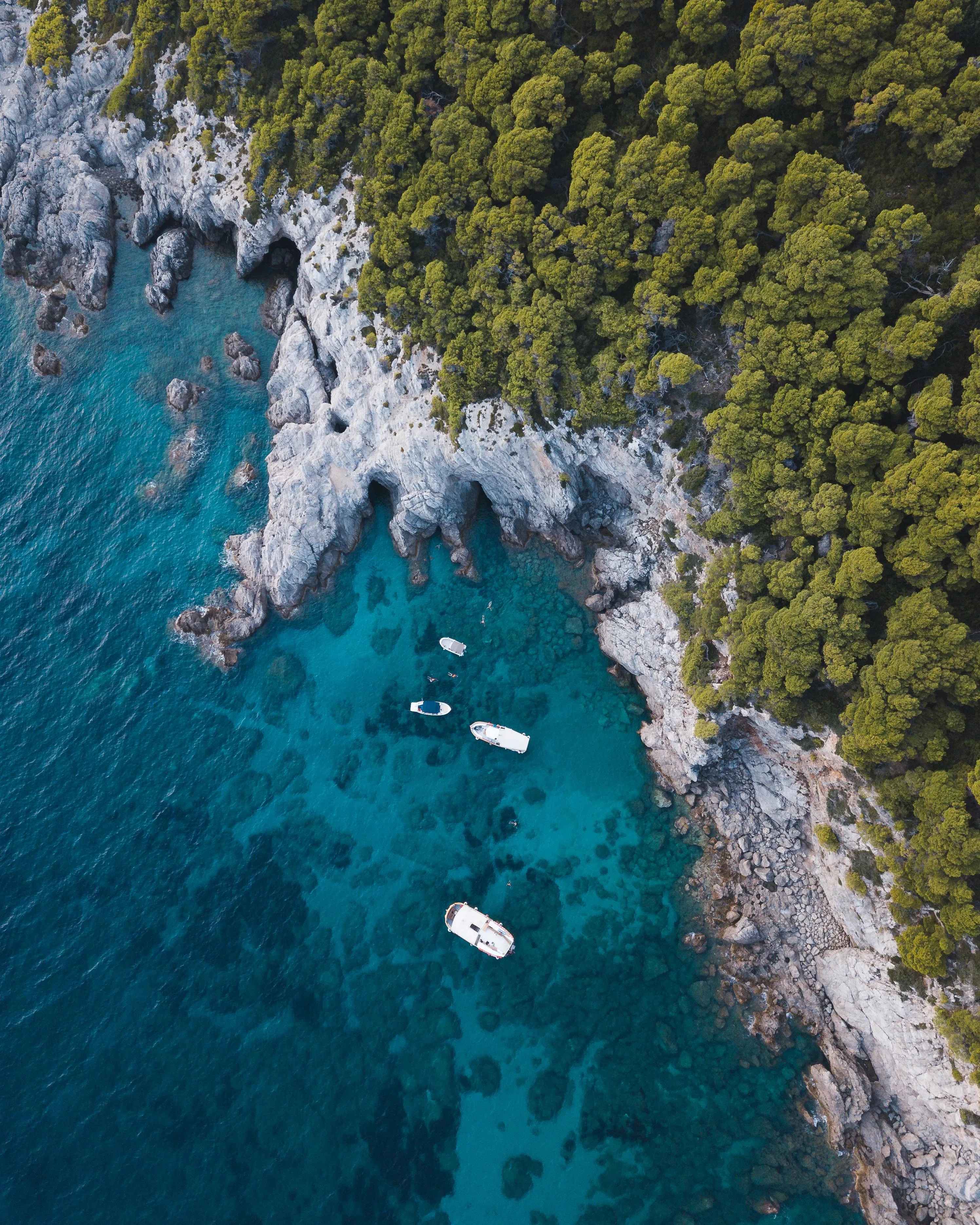 Aerial View of Boats on Clear Blue Water by Rocky Shoreline