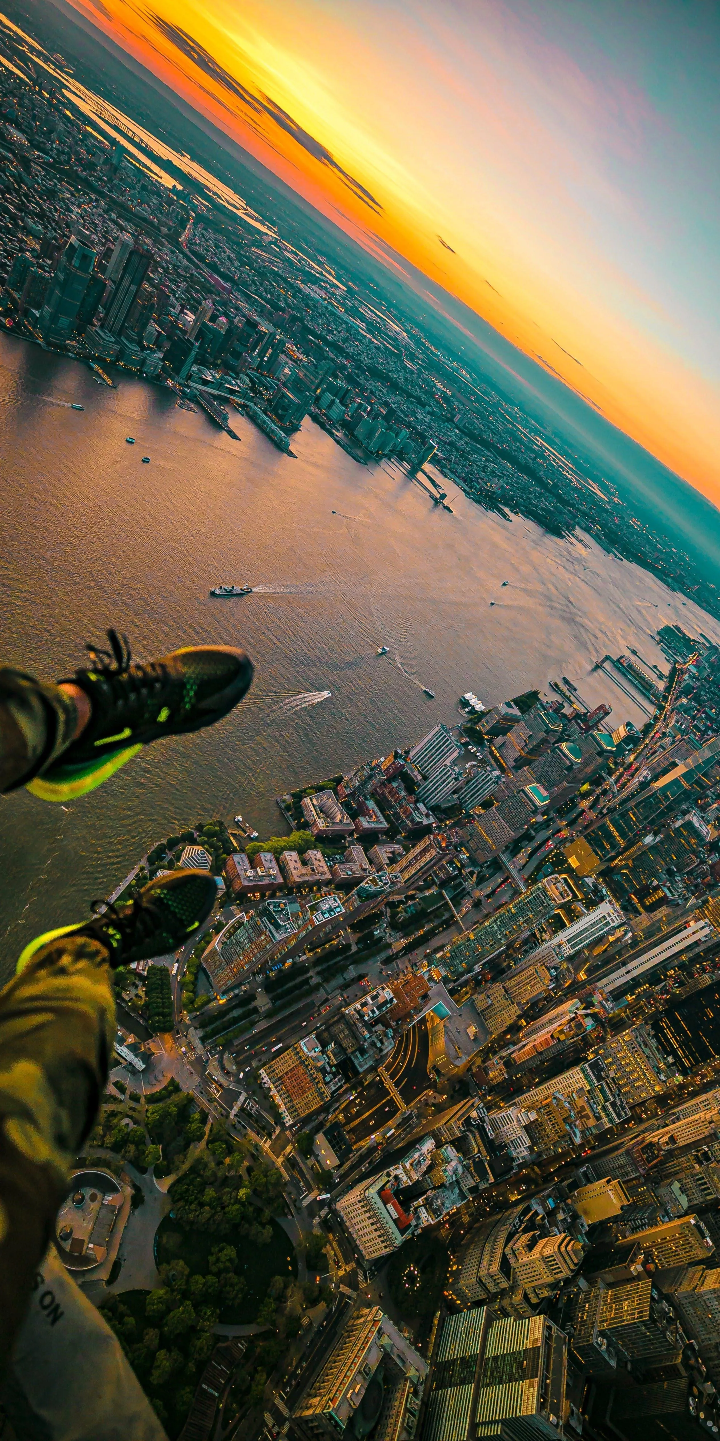 Aerial View of Cityscape with Person Legs Hanging Out