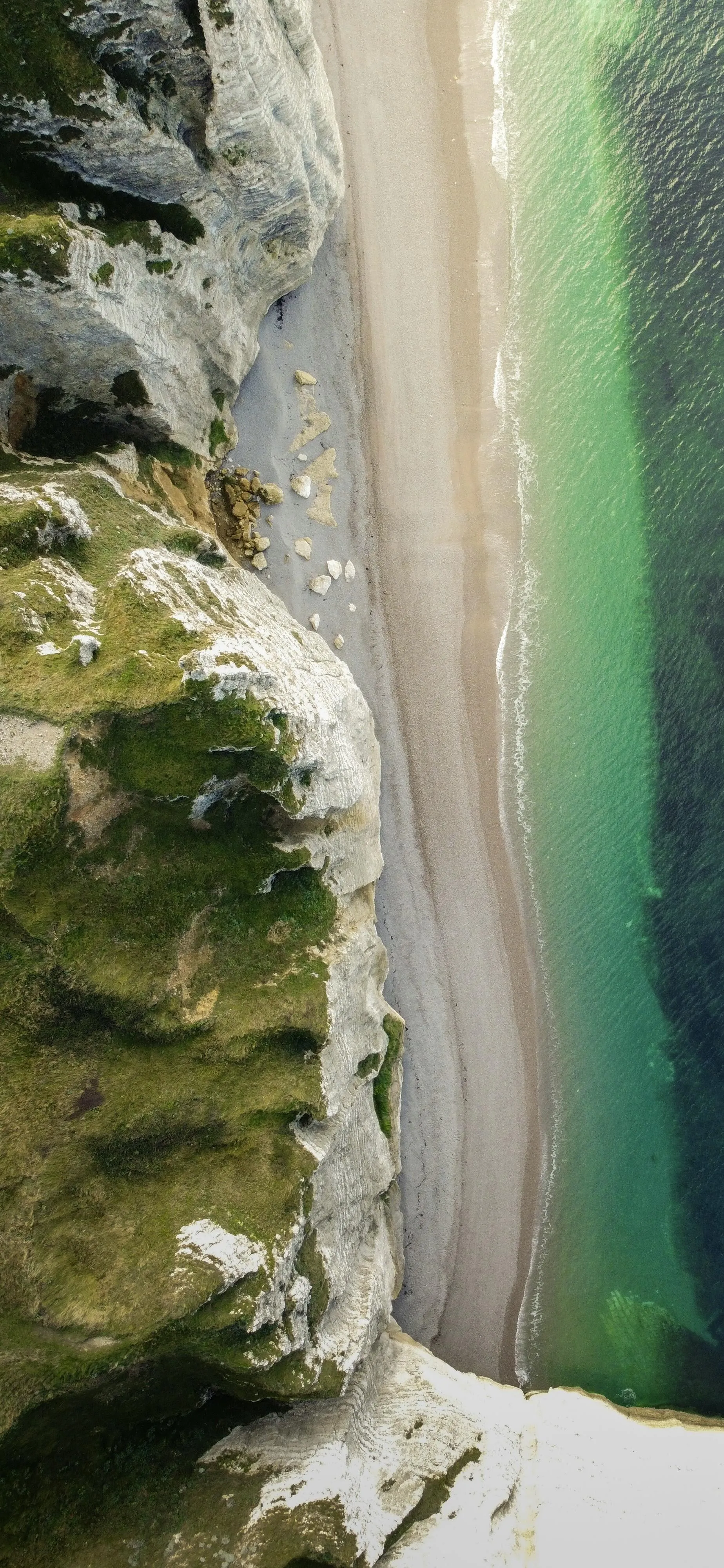 Aerial View of Cliffside and Ocean Waves Below Wallpaper