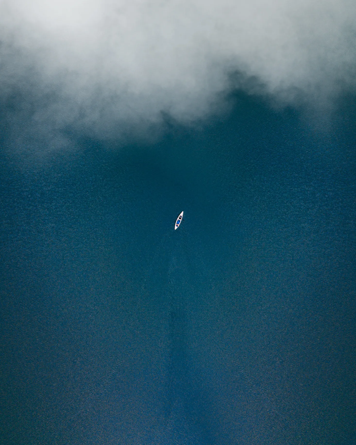 Aerial View of Kayak in Deep Blue Water and Mist Wallpaper