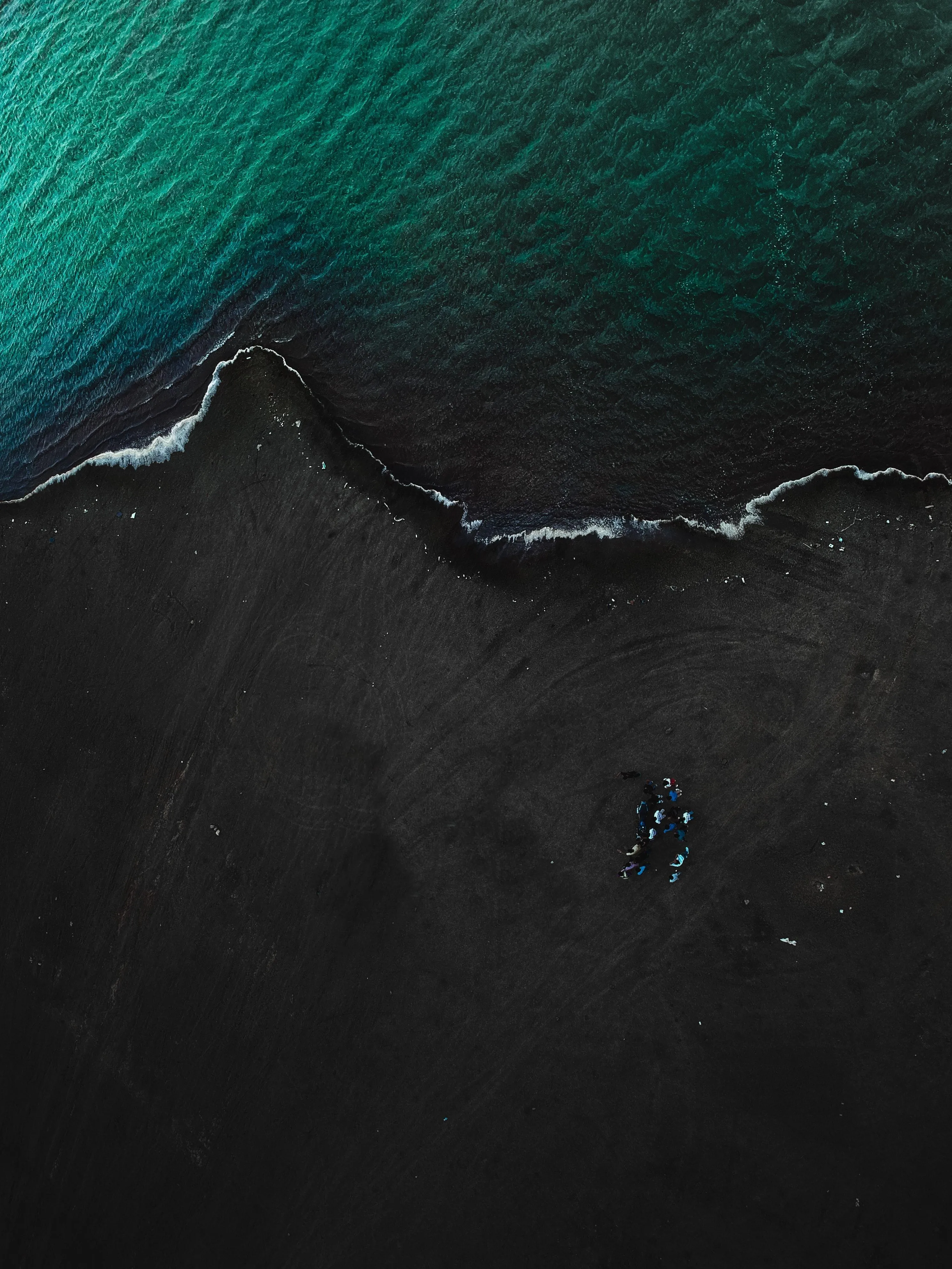 Aerial View of Ocean Waves Meeting Black Sand Shore
