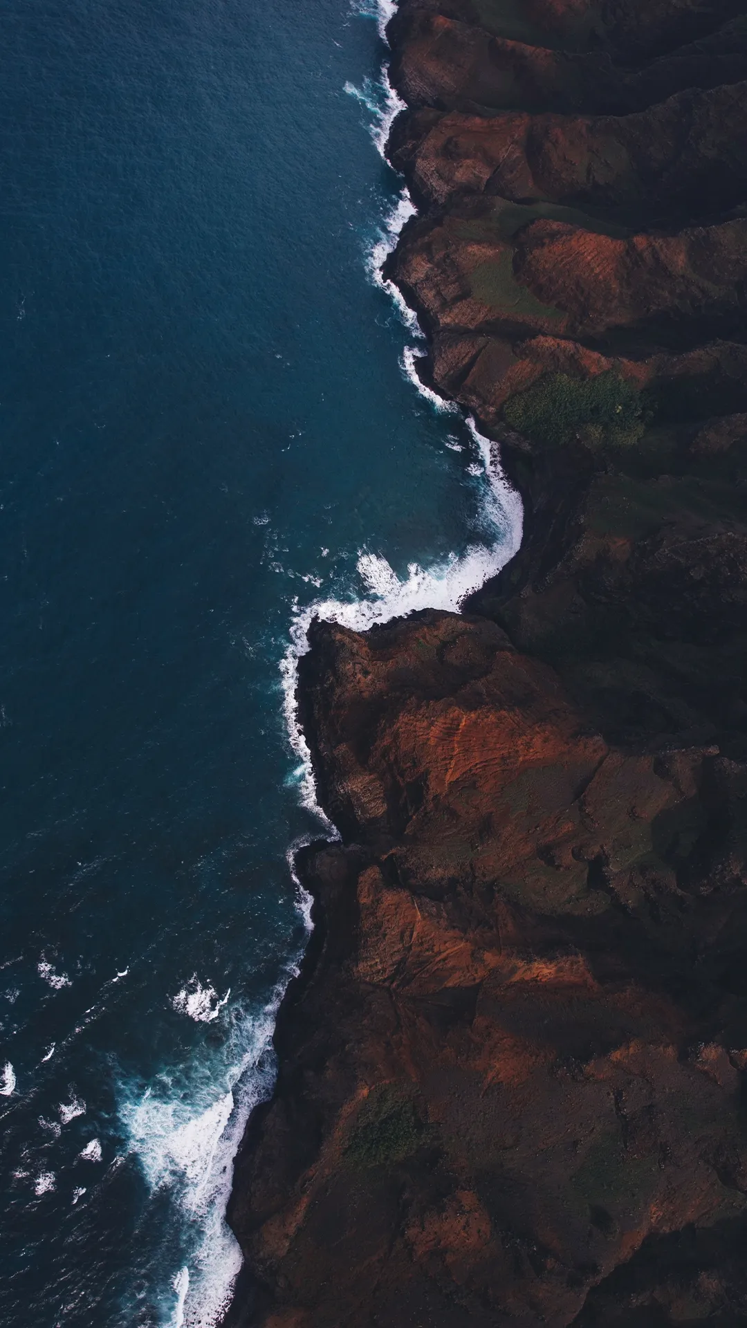 Aerial View of Rocky Shoreline with Ocean Waves Wallpaper