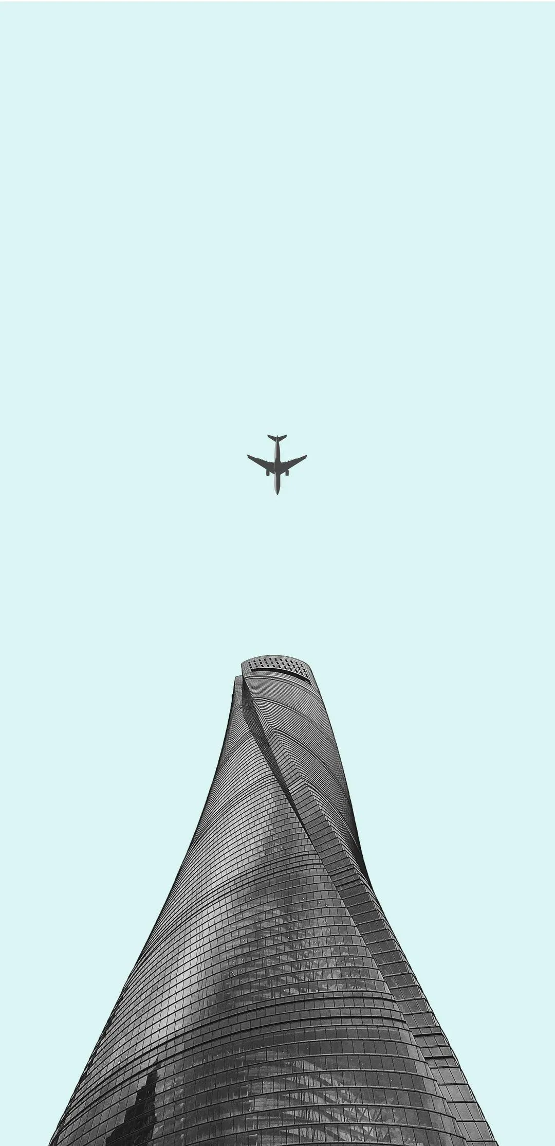 Airplane Flying Above a Modern Twisting Tower View