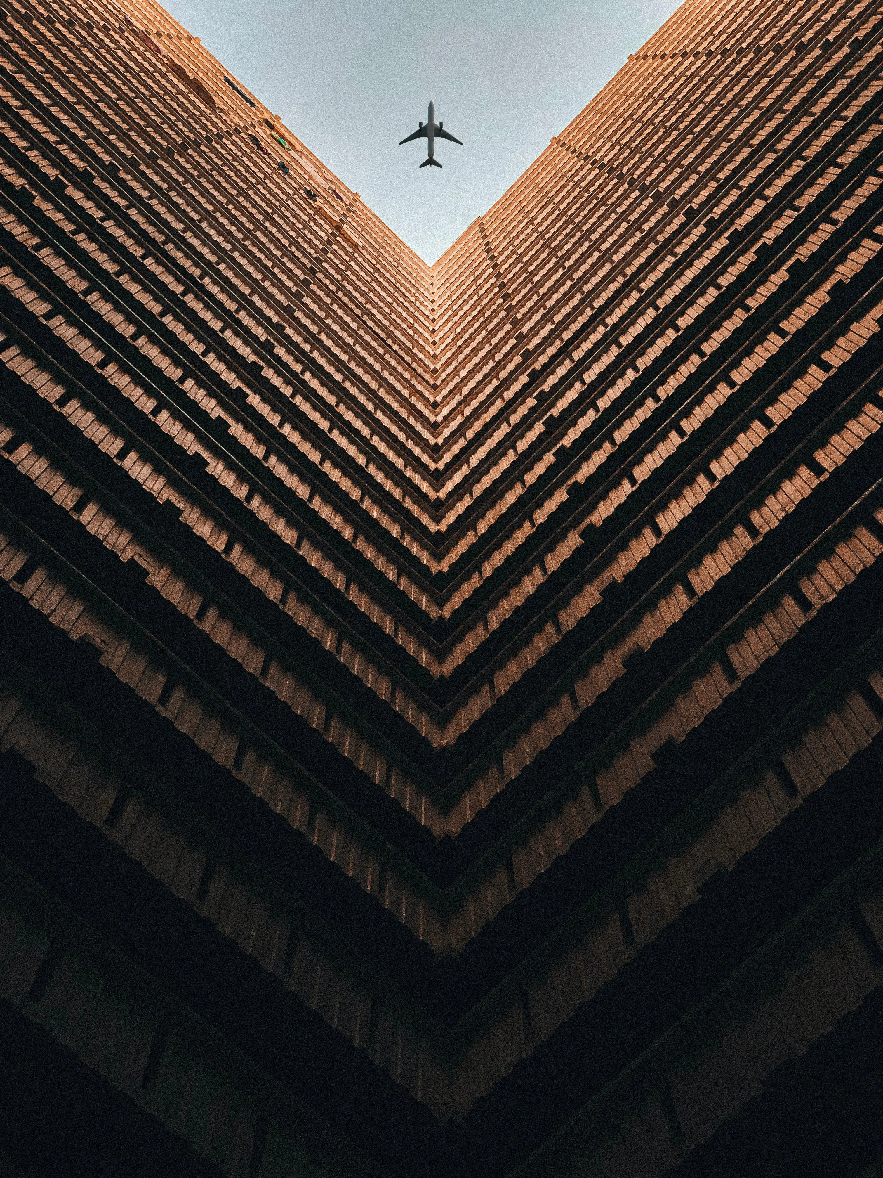 Airplane Flying Above Symmetrical City Buildings View