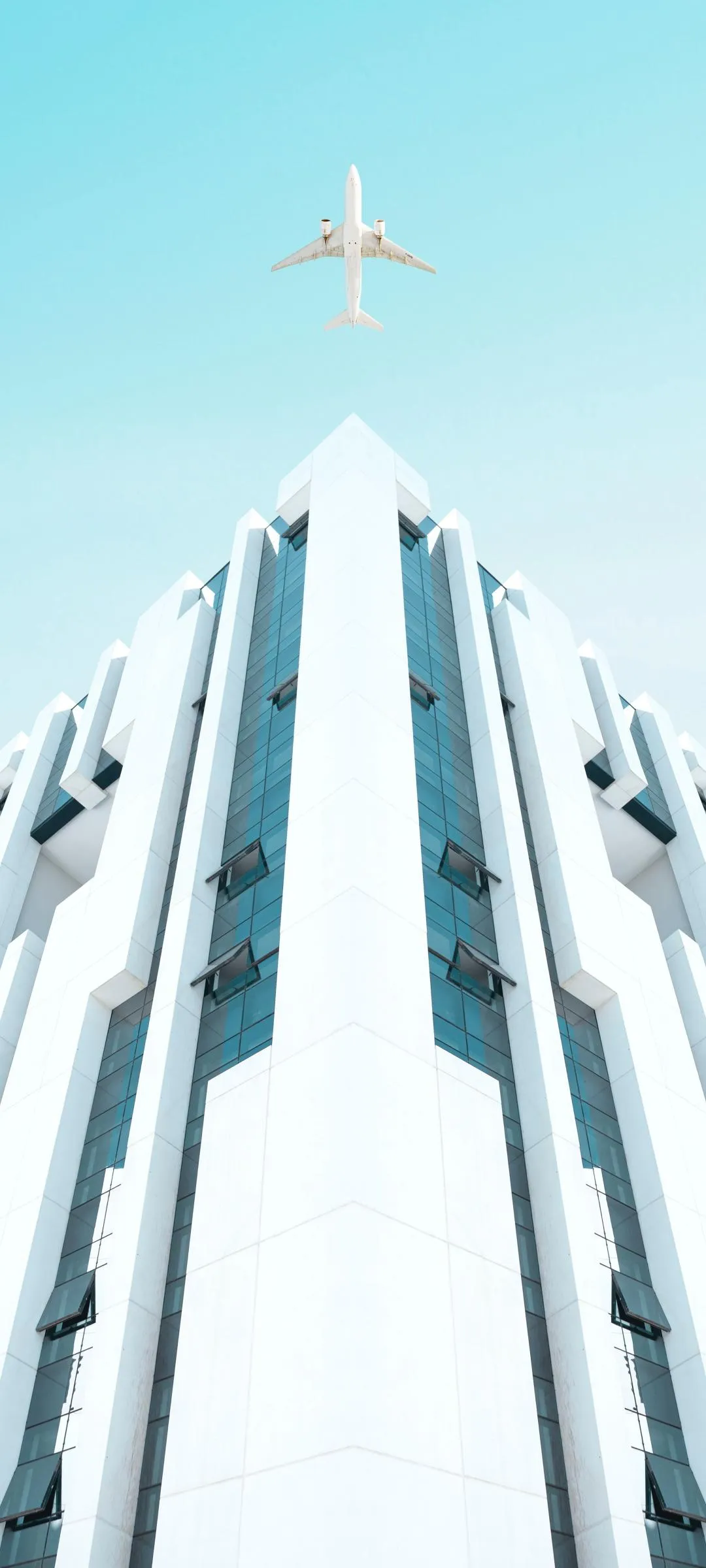 Airplane Flying Upward Through White Building Wallpaper