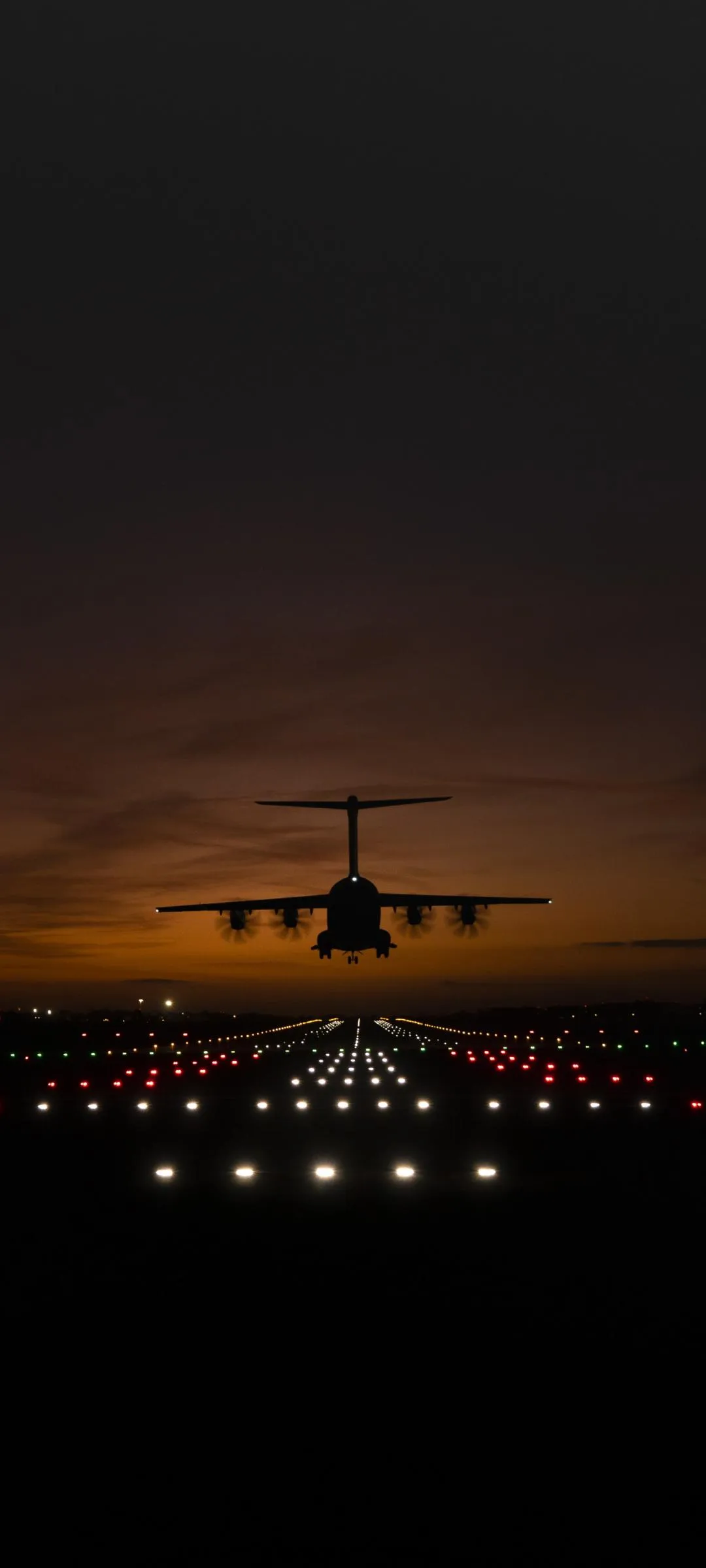 Airplane Landing at Sunset Over Calm Runway Wallpaper