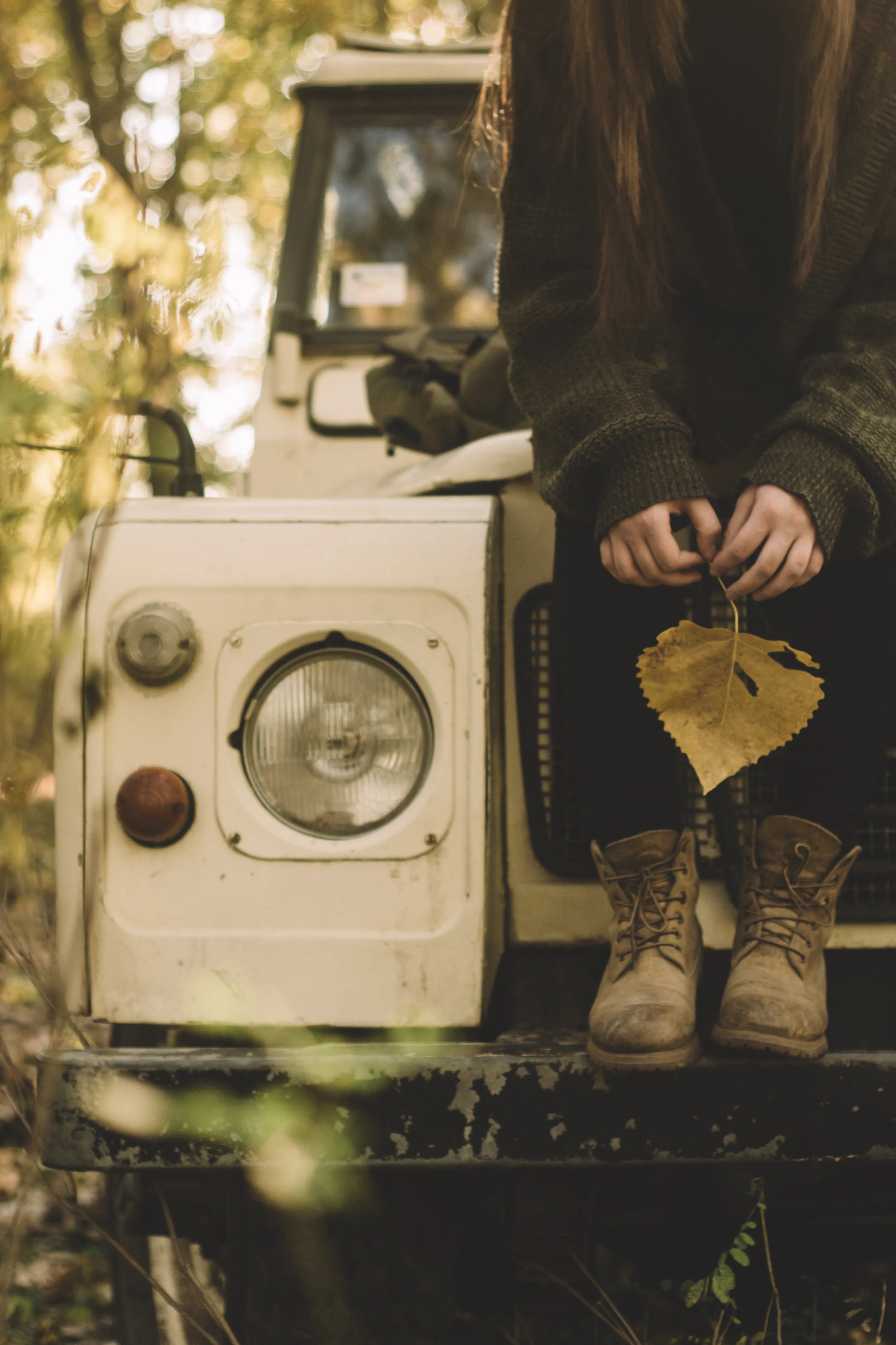Autumn Moment Sitting on Old Vehicle with Leaf in Hand