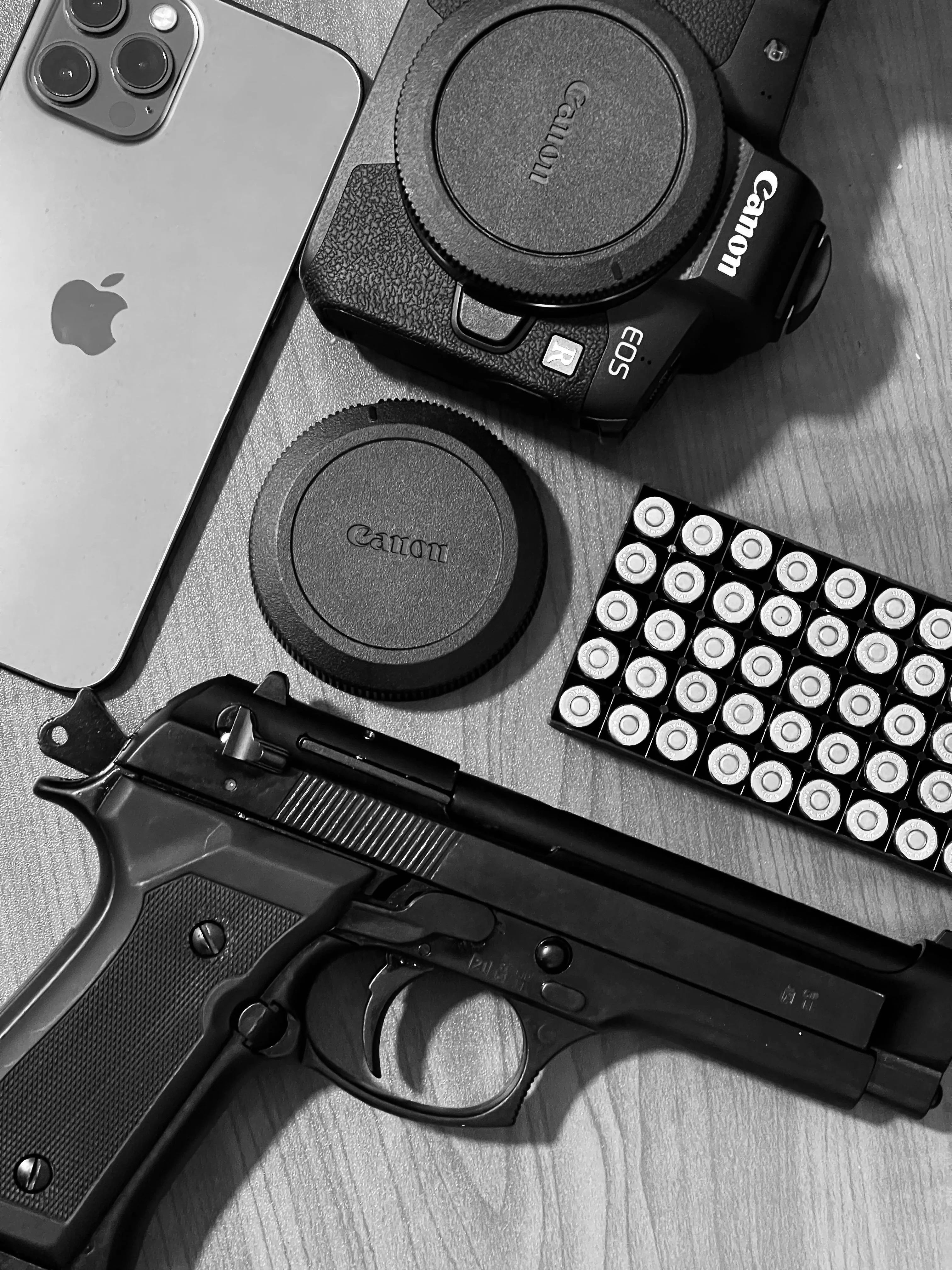 Black and White Flat Lay of Gun Applephone and Gadgets