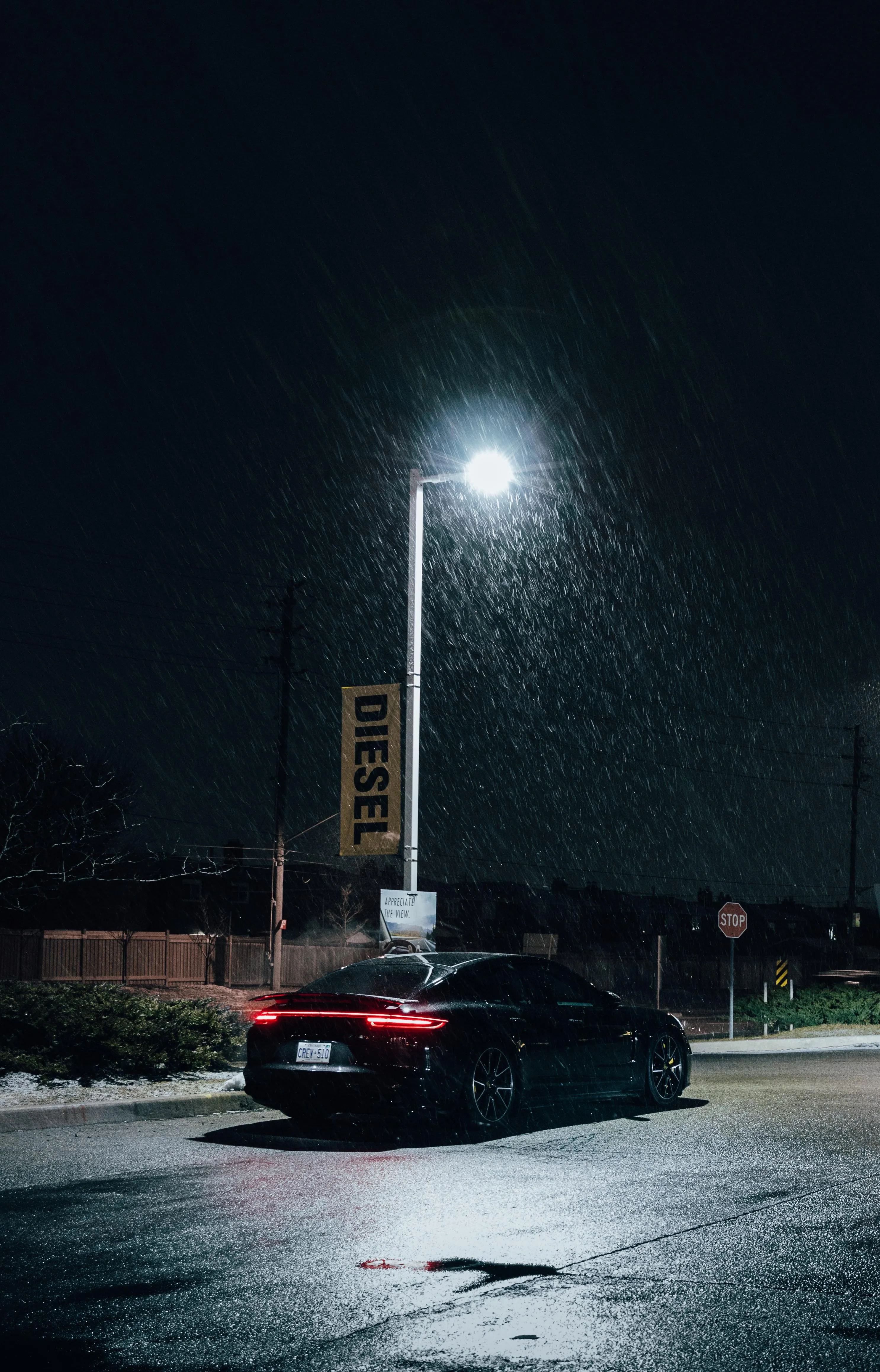 Black Car Parked Under Streetlight on Quiet Night Wallpaper