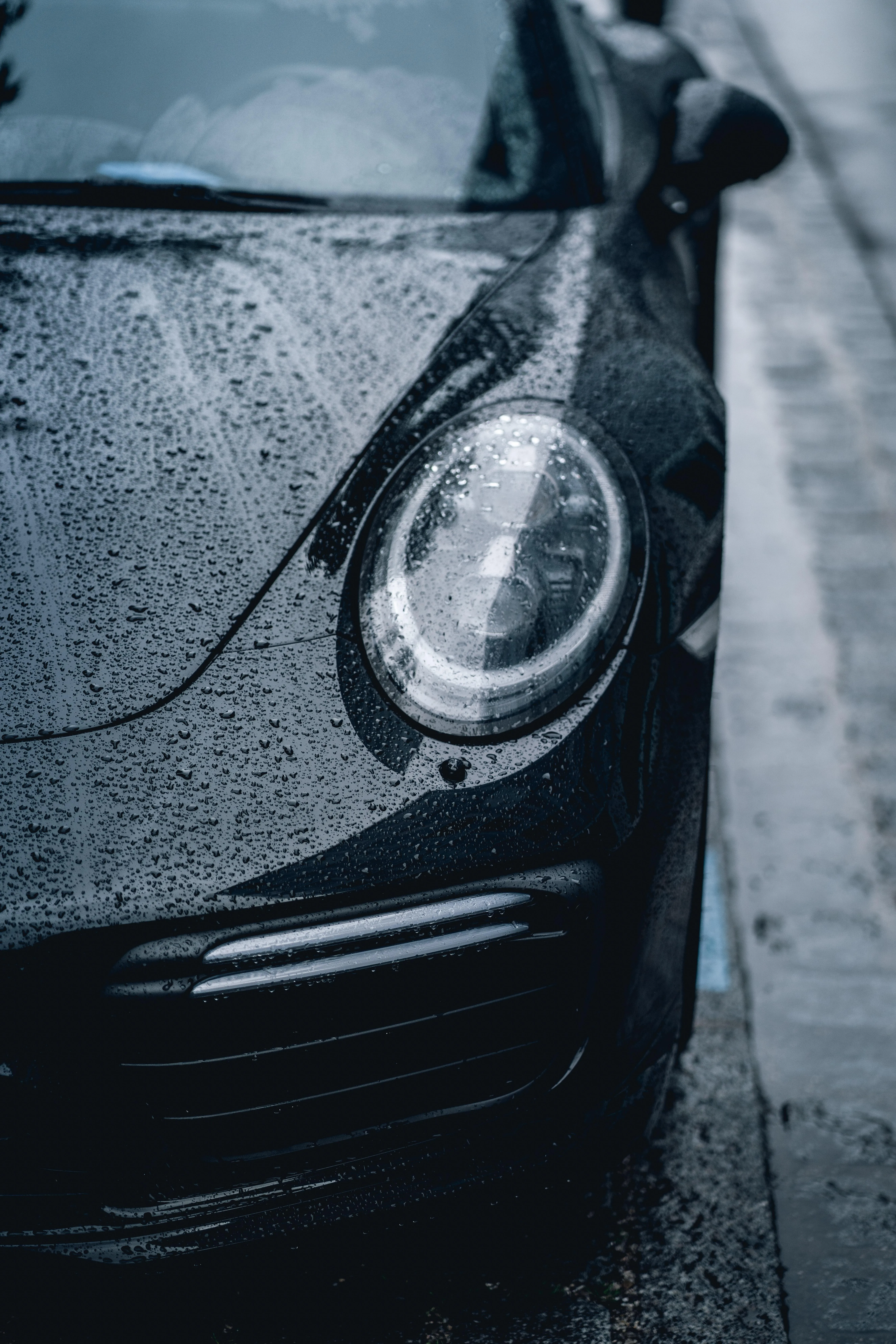 Black Sports Car Covered in Raindrops Closeup View Image