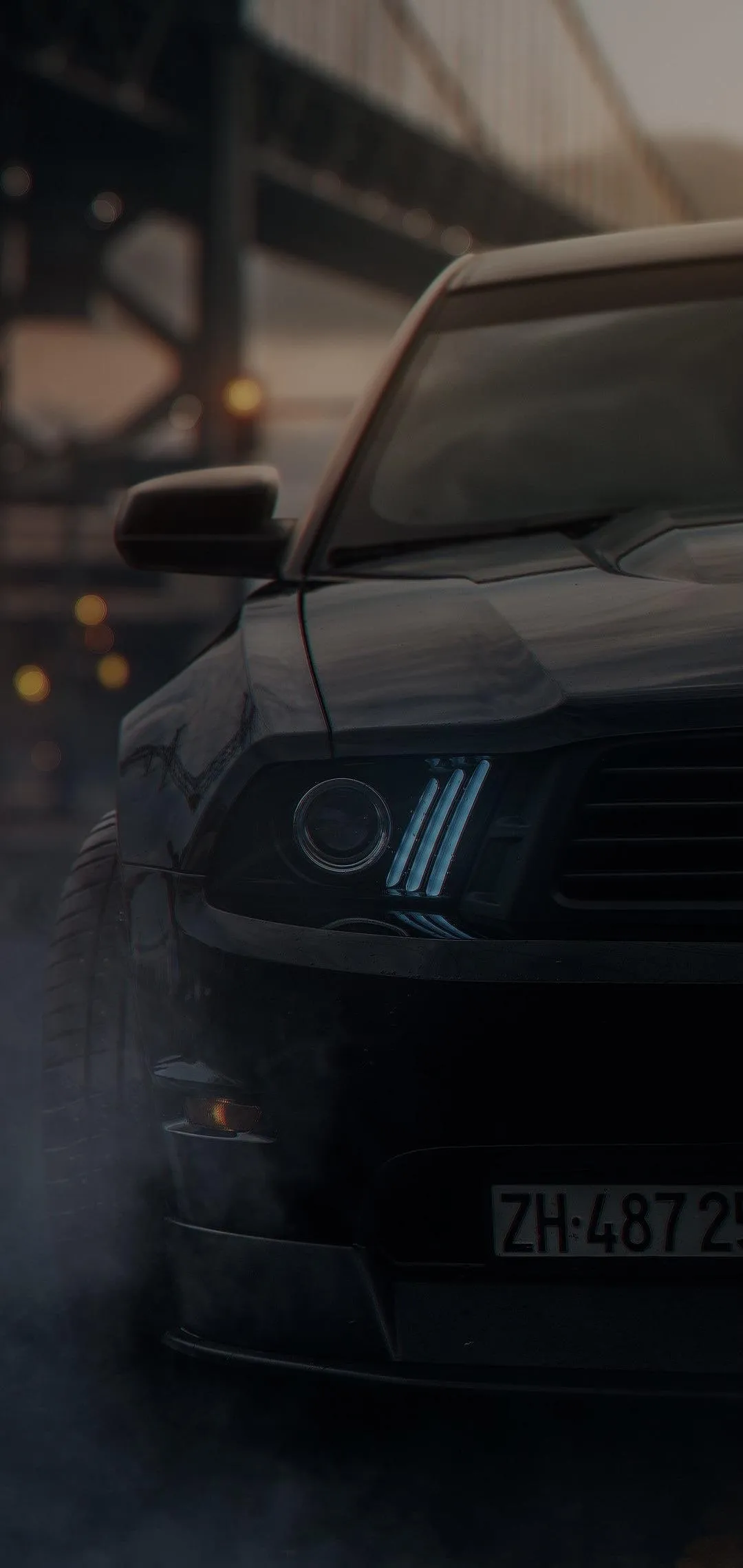 Black Sports Car Surrounded by Smoke in Dark Street