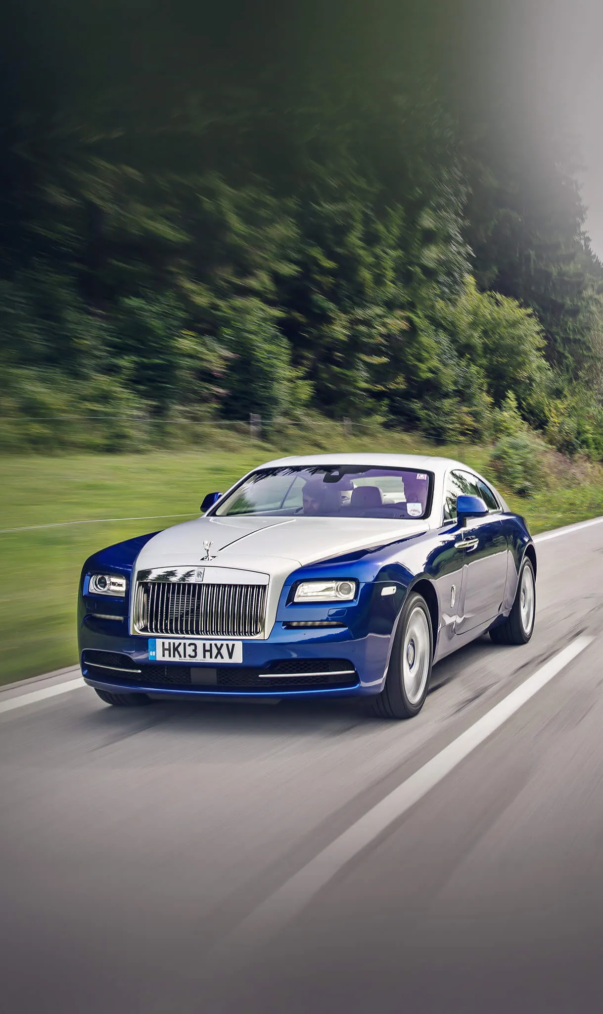Blue Sports Car in Motion on Green Forest Road Wallpaper
