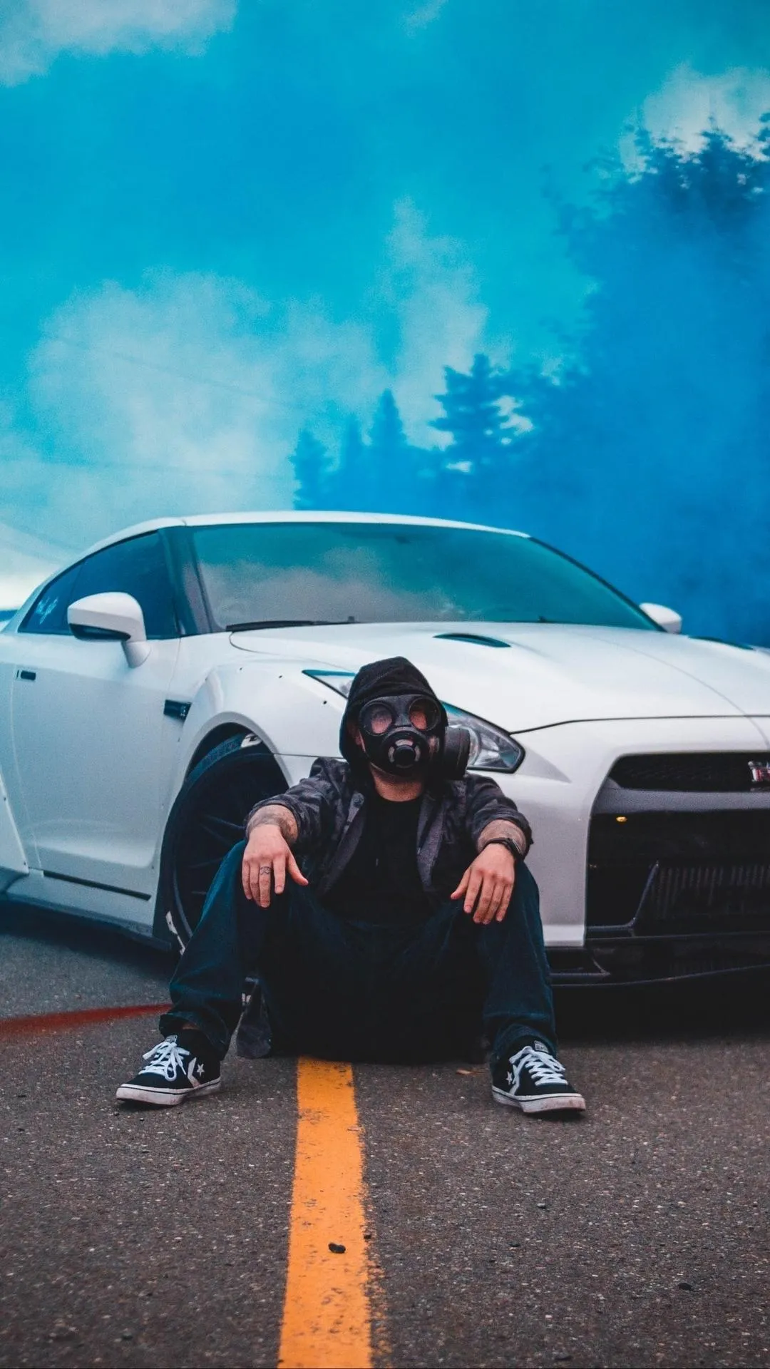 Boy Sitting on Road Near Car with Blue Sky Background