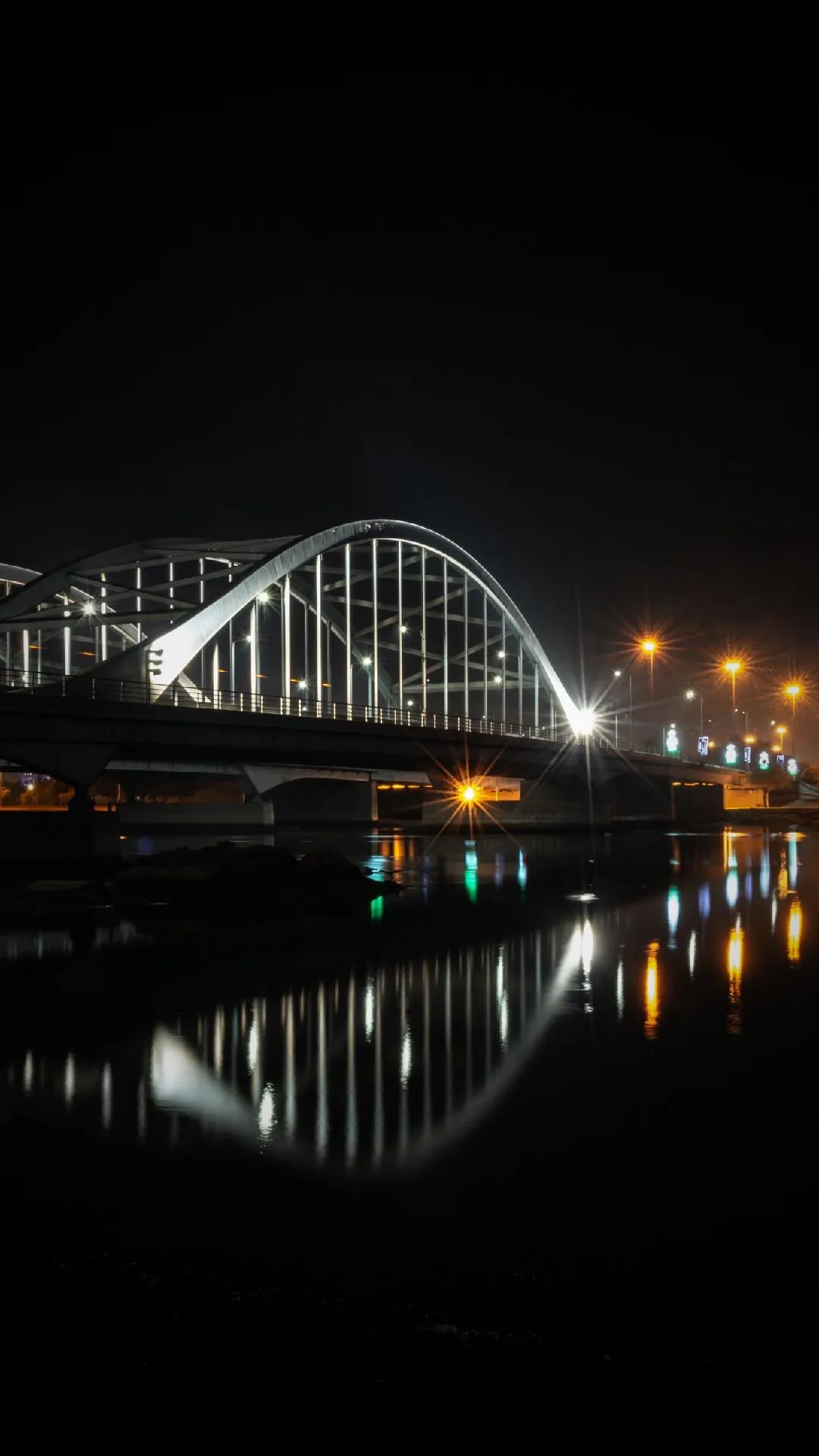 Bridge Reflected Over River Under City Night Lights Image