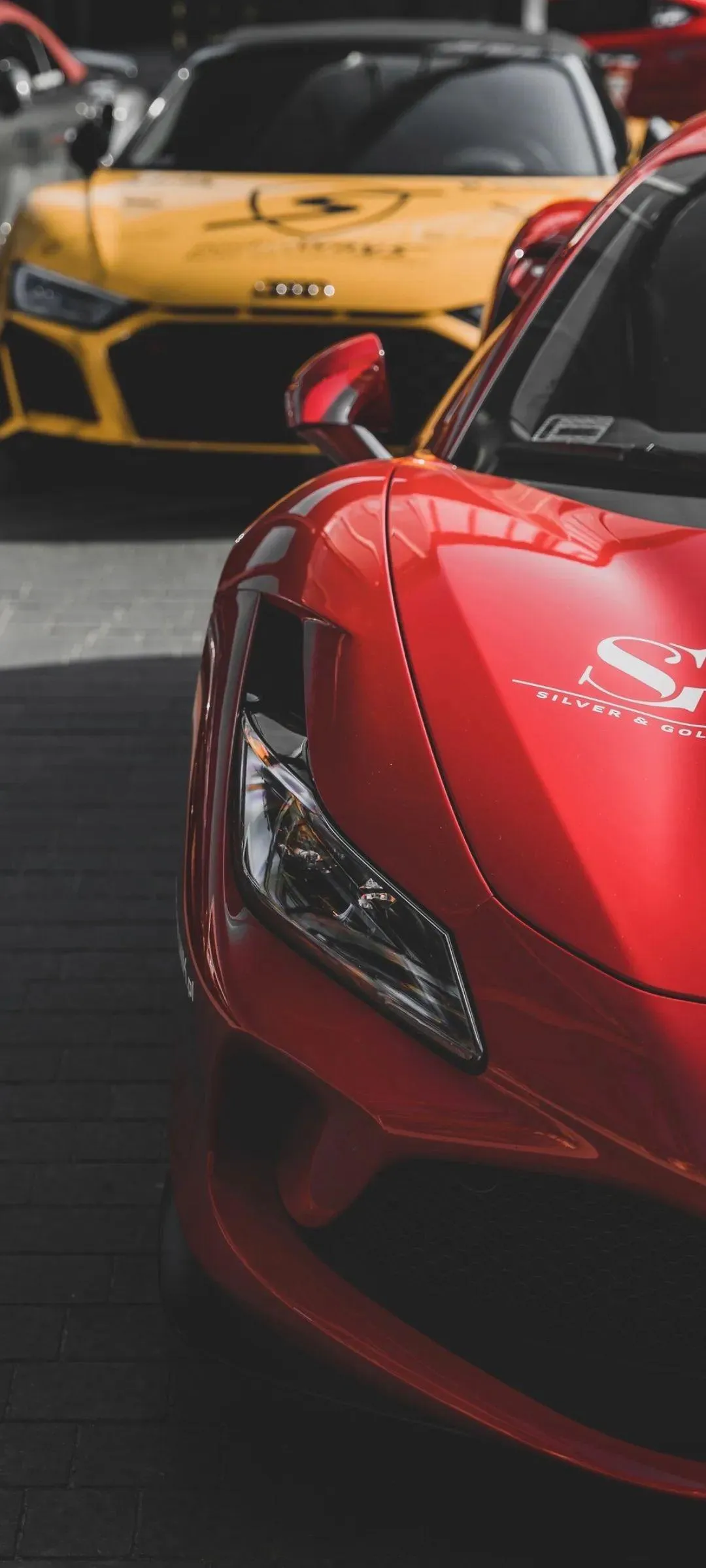 Bright Red Sports Car in Urban Night Setting Wallpaper