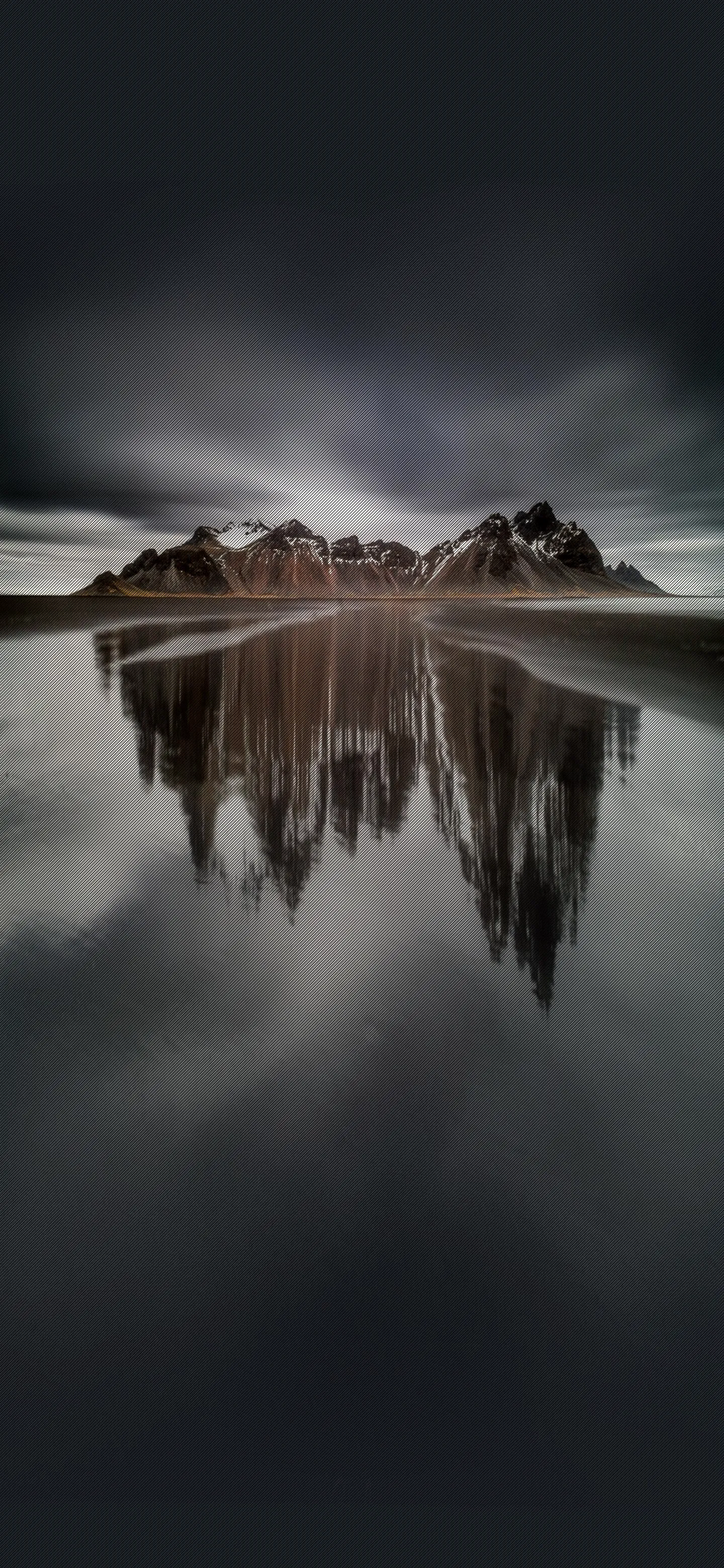 Calm Lake with Mountain Reflection Under Cloudy Sky Image