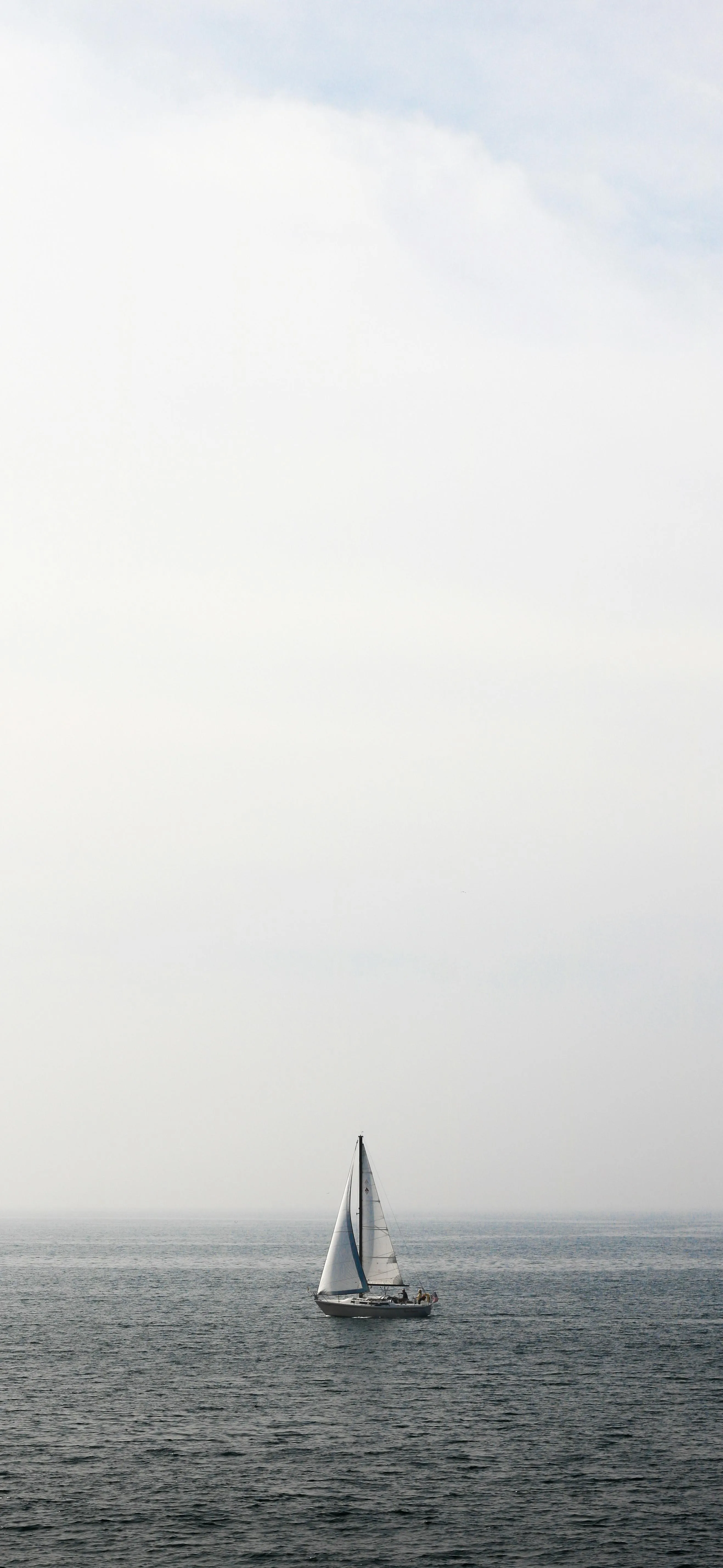 Calm Ocean View with Distant Sailing Boat Free Image