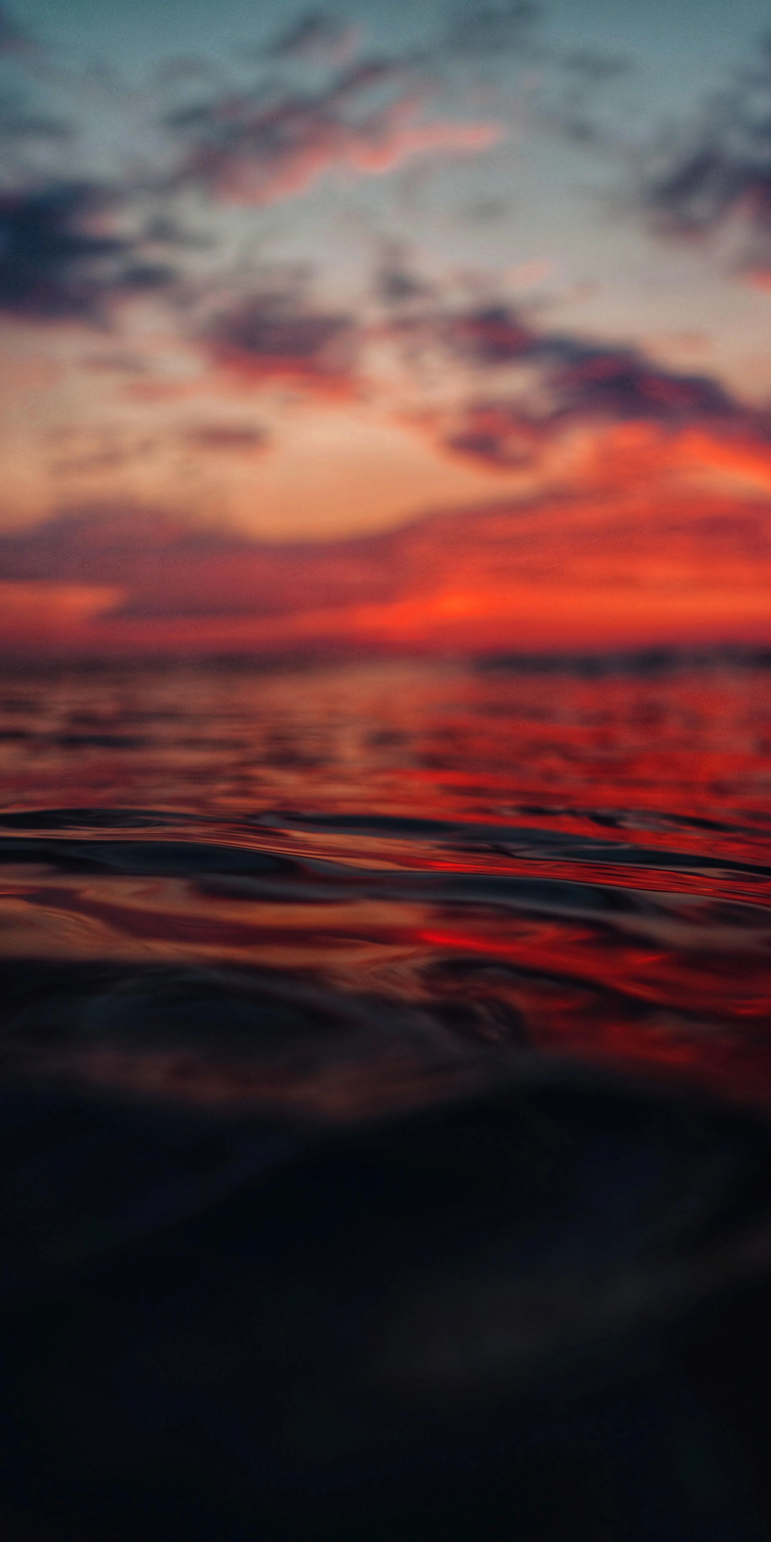 Calm Sunset Over Ocean with Soft Cloud and Orange Sky