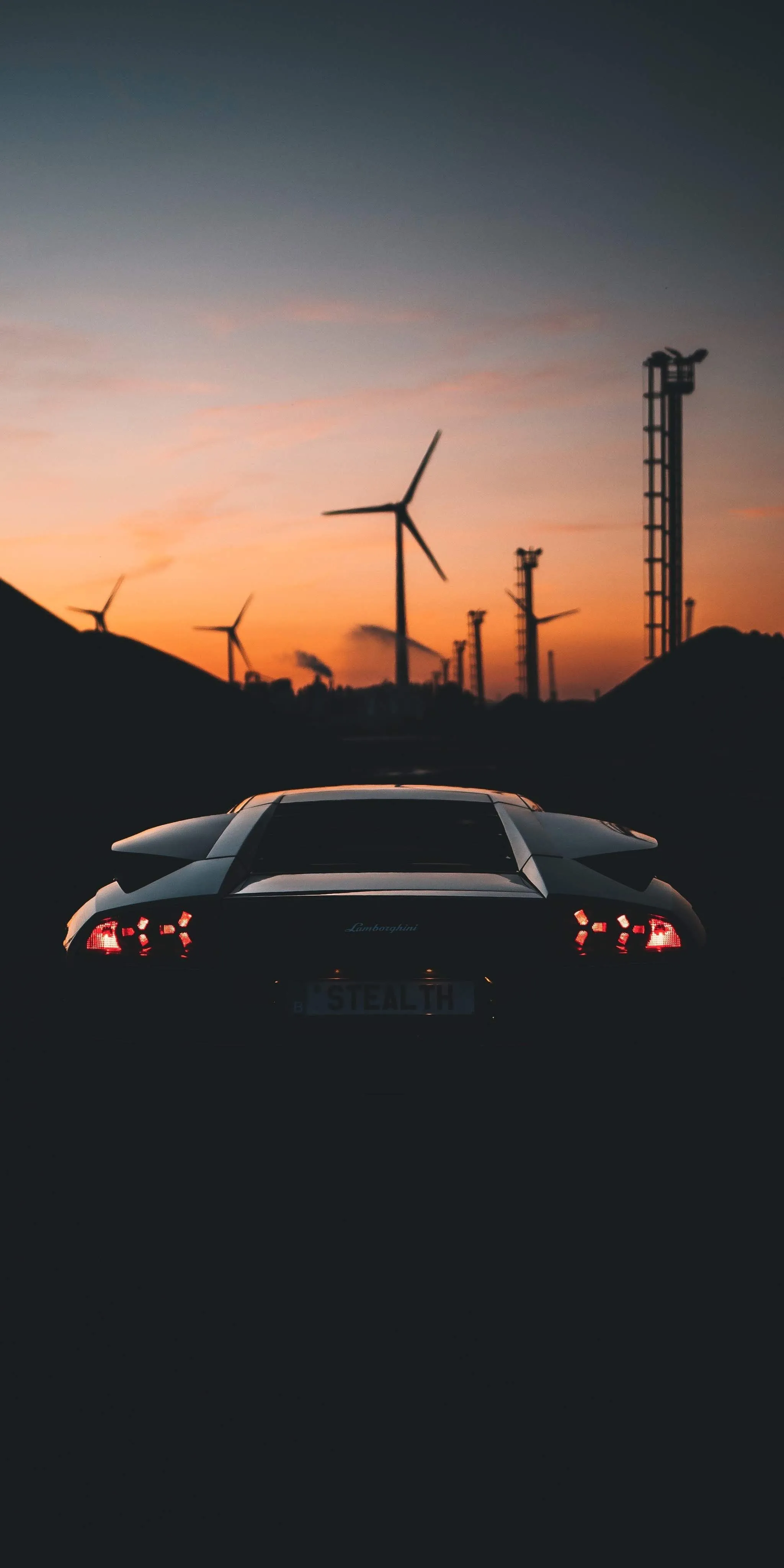 Car Driving Toward Windmills in Sunset Light Wallpaper