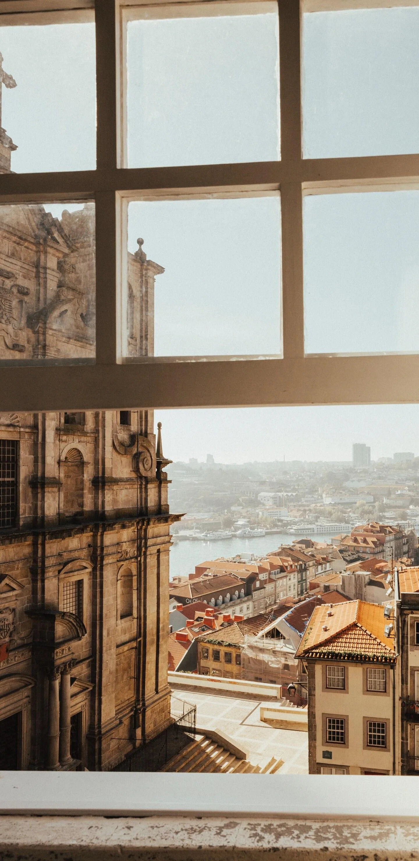 City View from Window Overlooking Rooftops and Urban Skyline