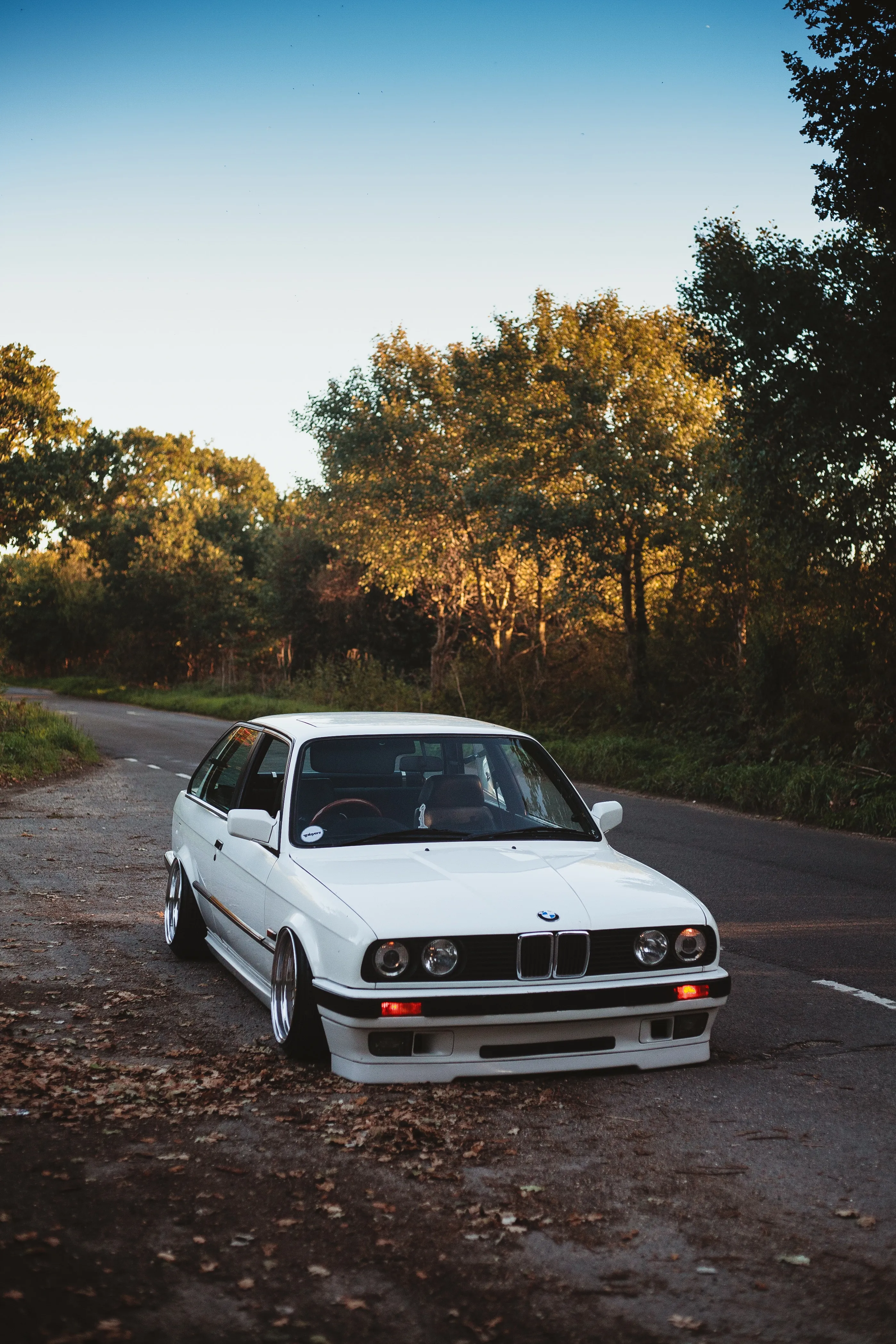 Classic White Car Parked Beside Country Road Wallpaper