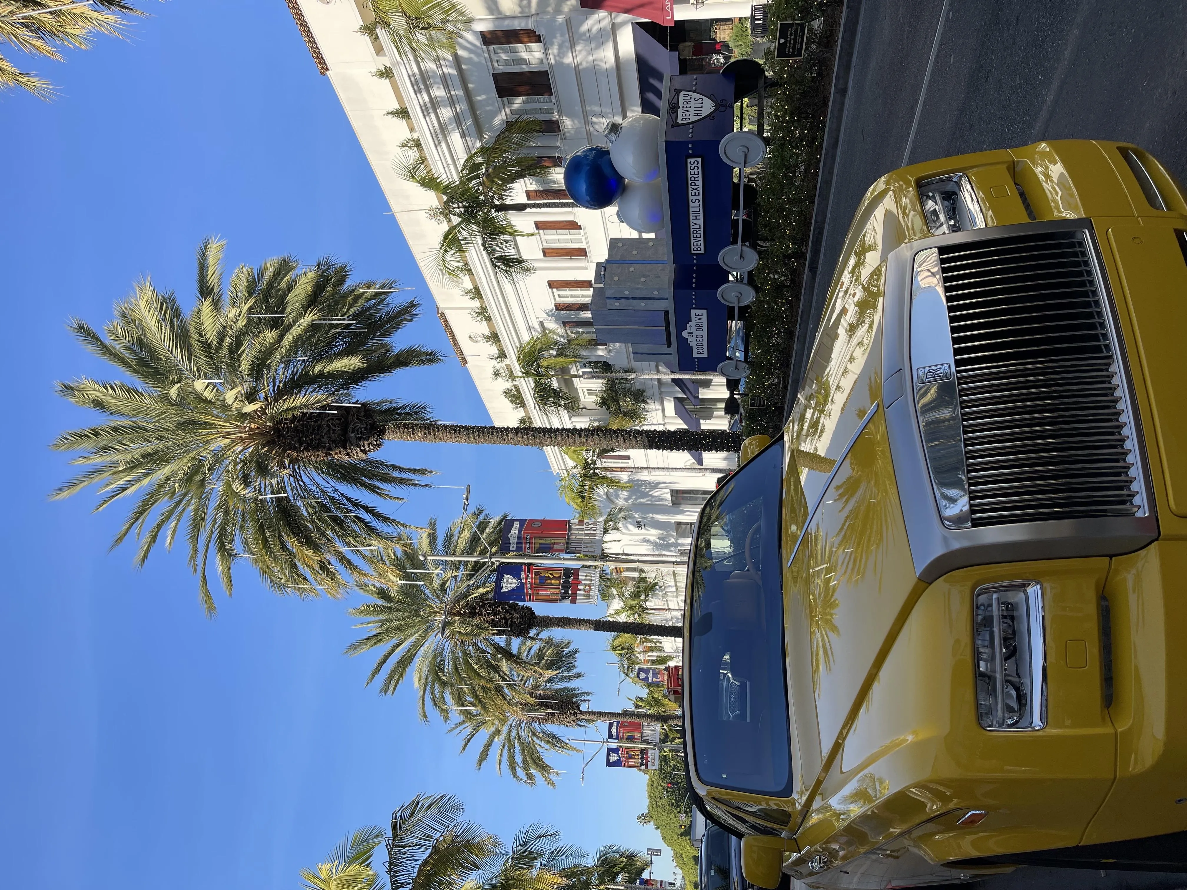 Classic Yellow Car Parked on a Sunny Palm Tree Lined Street