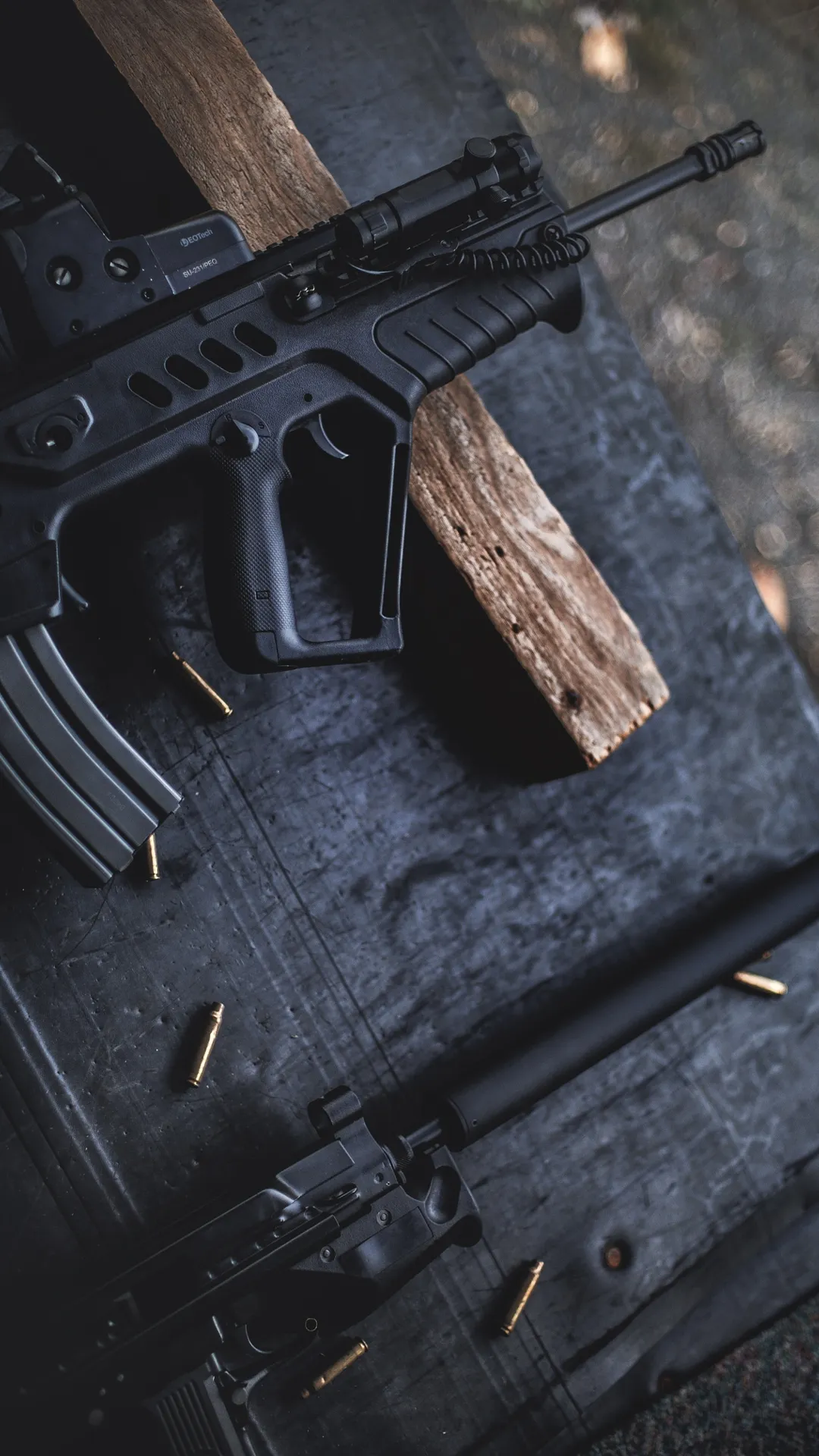Close Up of Black Gun with Wooden Handle on Dark Surface