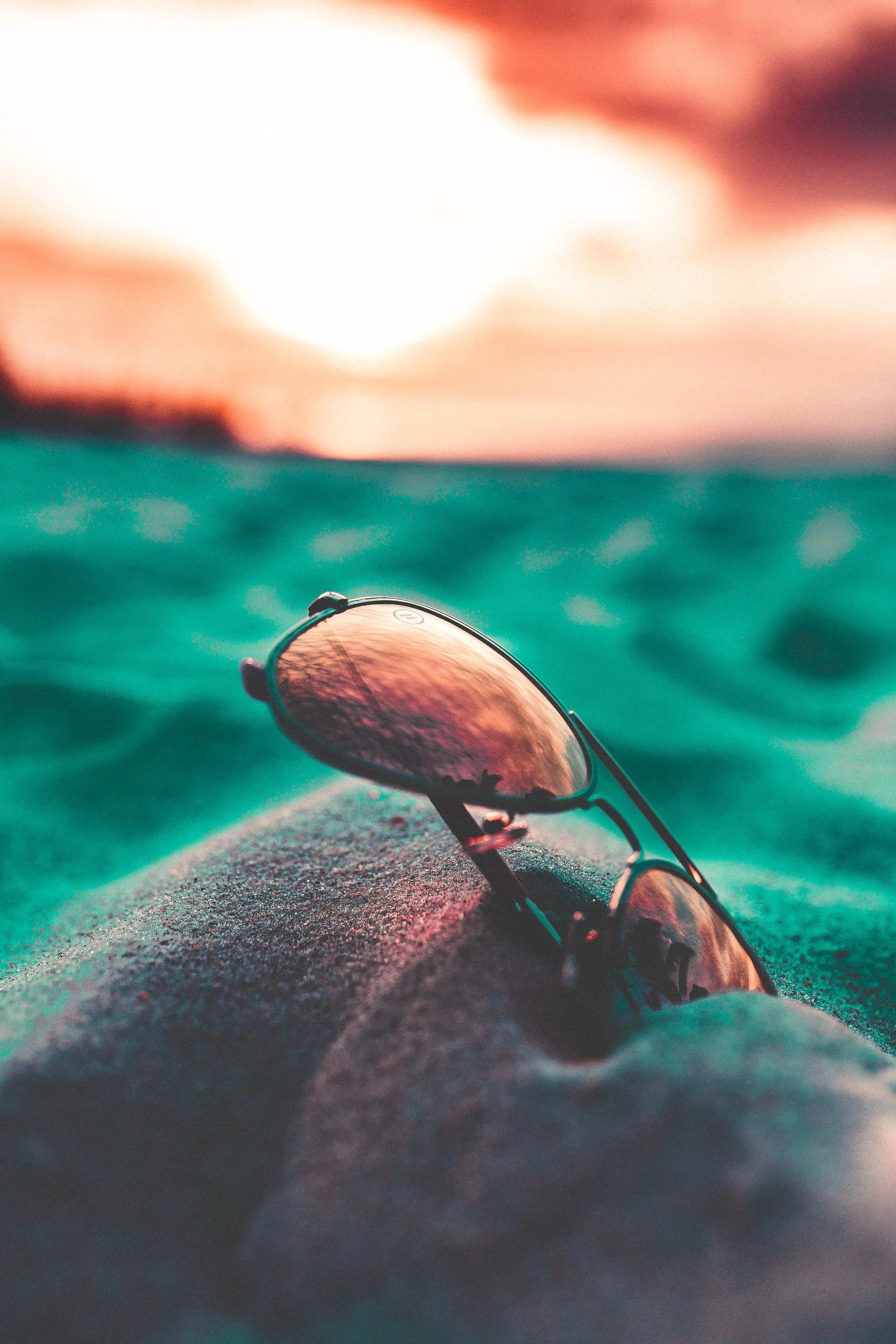 Close Up of Sunglasses on Beach Sand at Sunset Hour