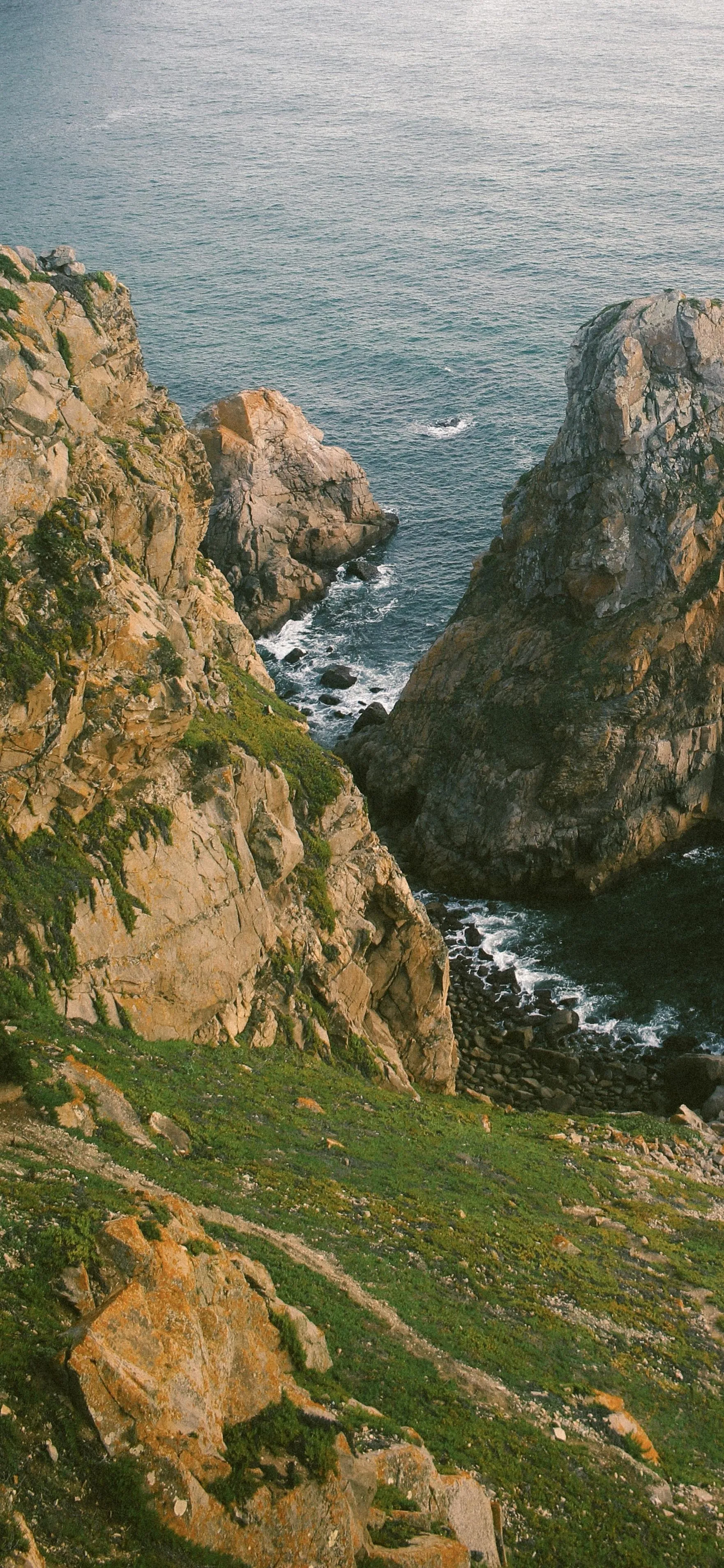 Coastal Cliffs Meeting Blue Sea Under Sunny Skies Wallpaper