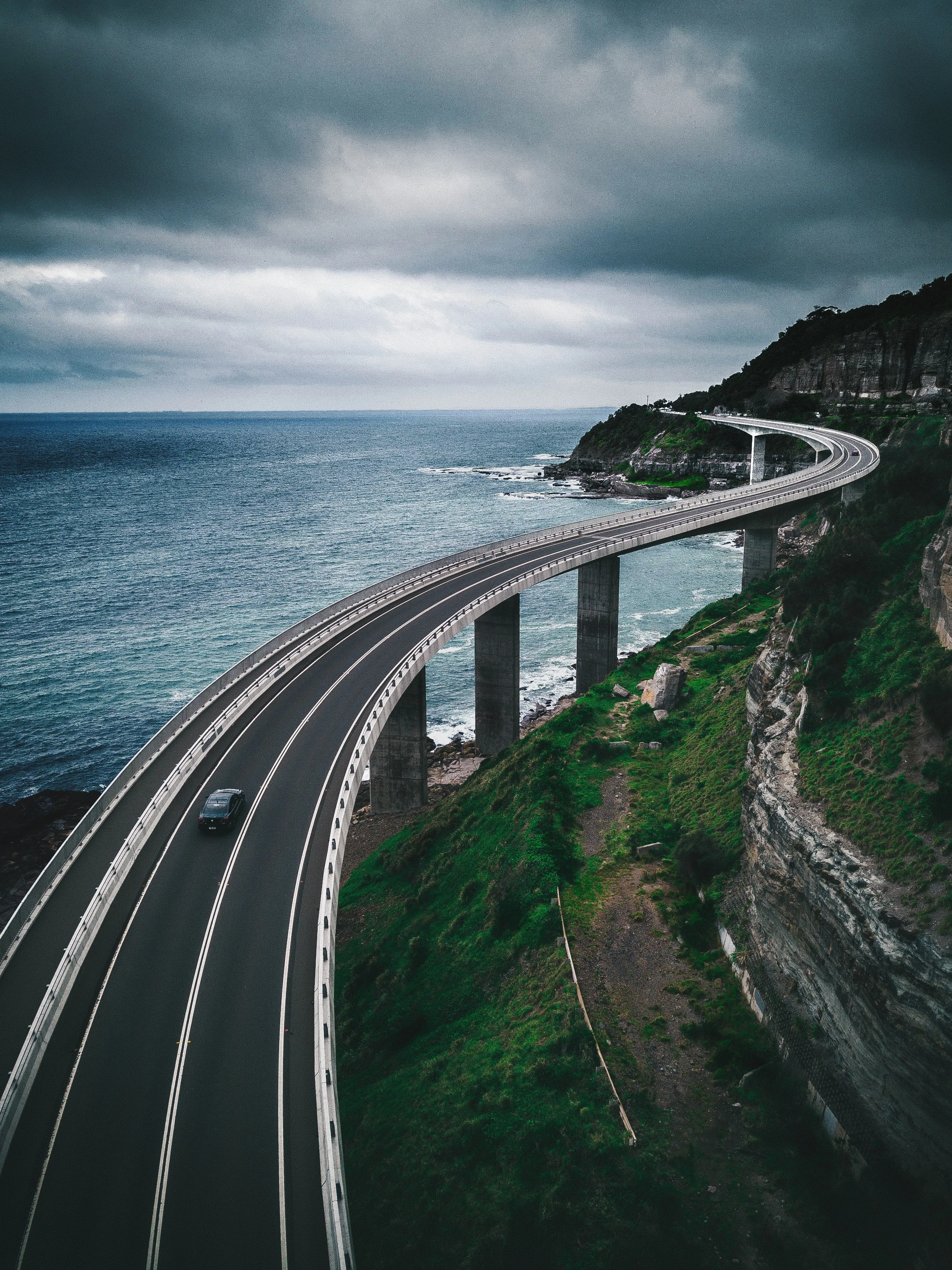Coastal Highway Curving Beside Calm Ocean Cliffs Wallpaper