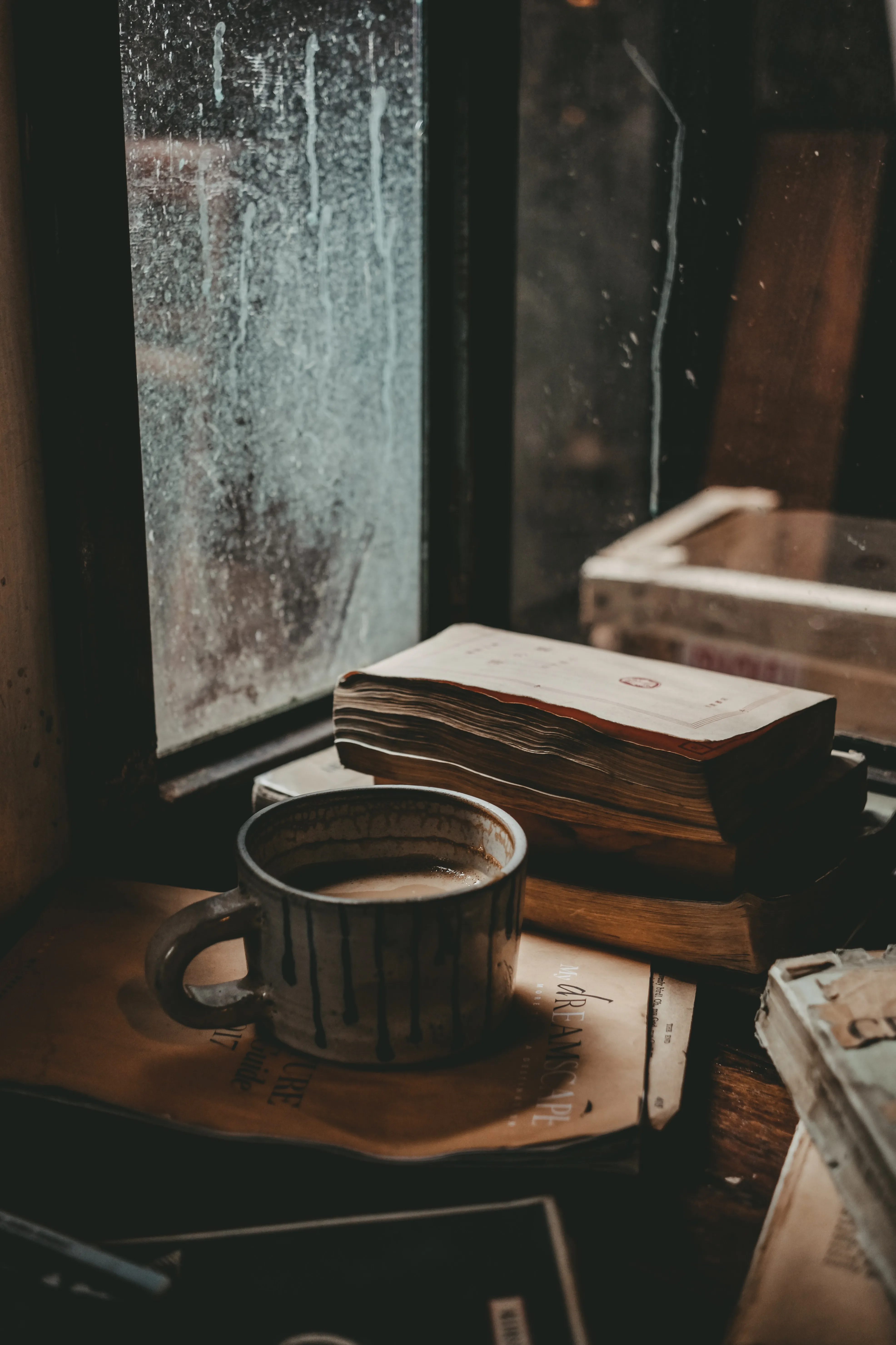 Cozy Coffee Cup Beside Books on Wooden Table Wallpaper