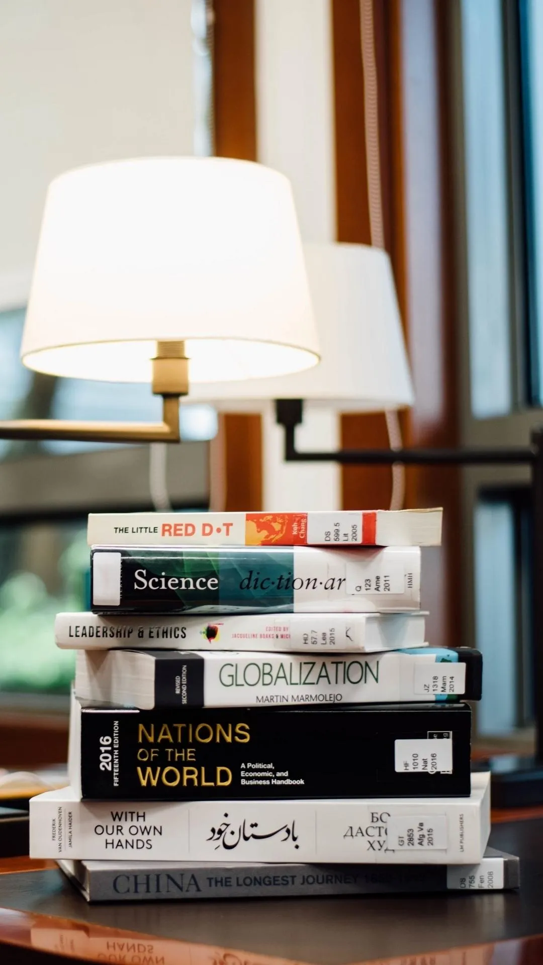 Cozy Reading Corner With Stacked Books and Lamp Wallpaper