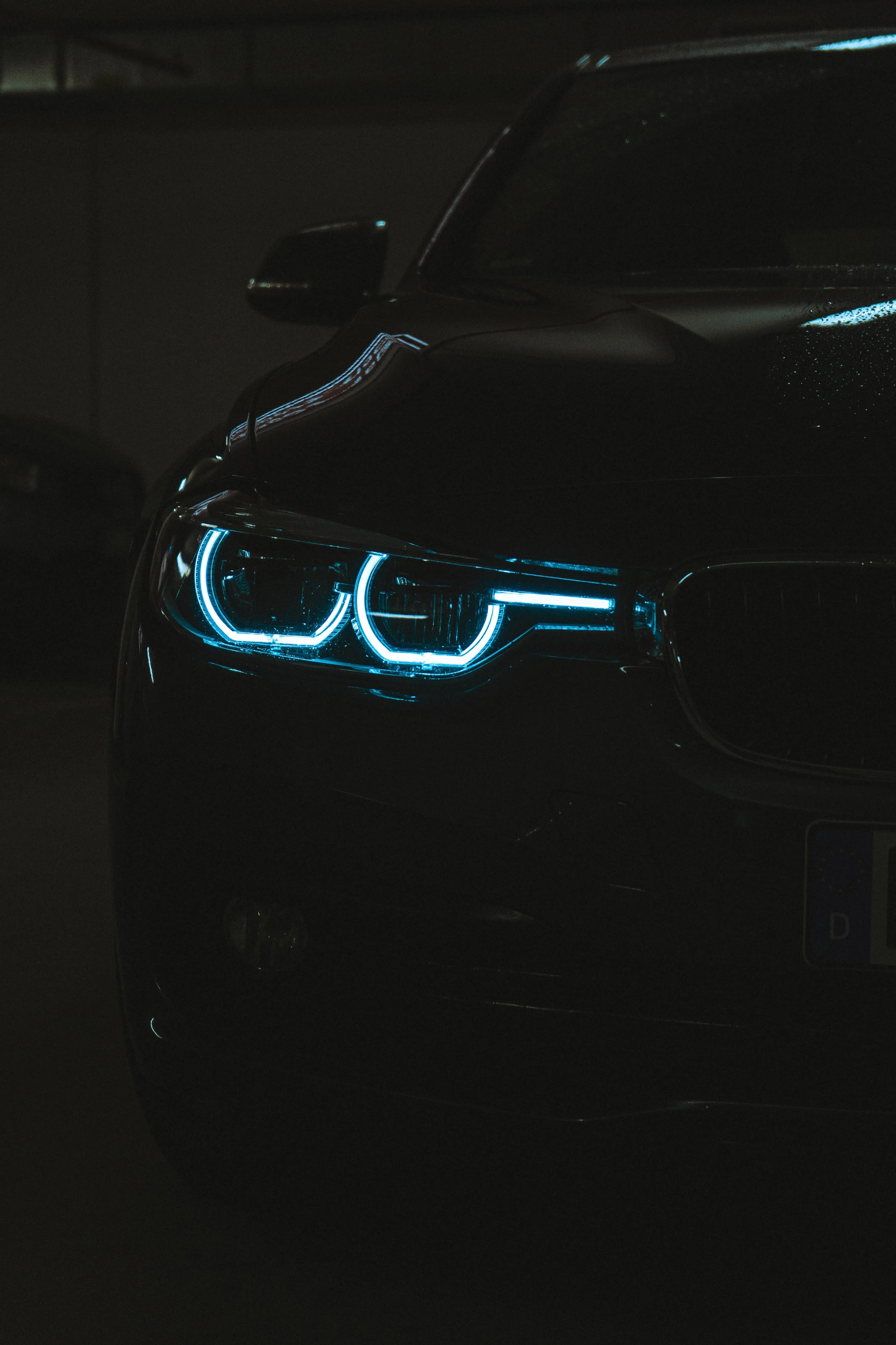 Dark Luxury Car with Glowing Blue Headlights Wallpaper