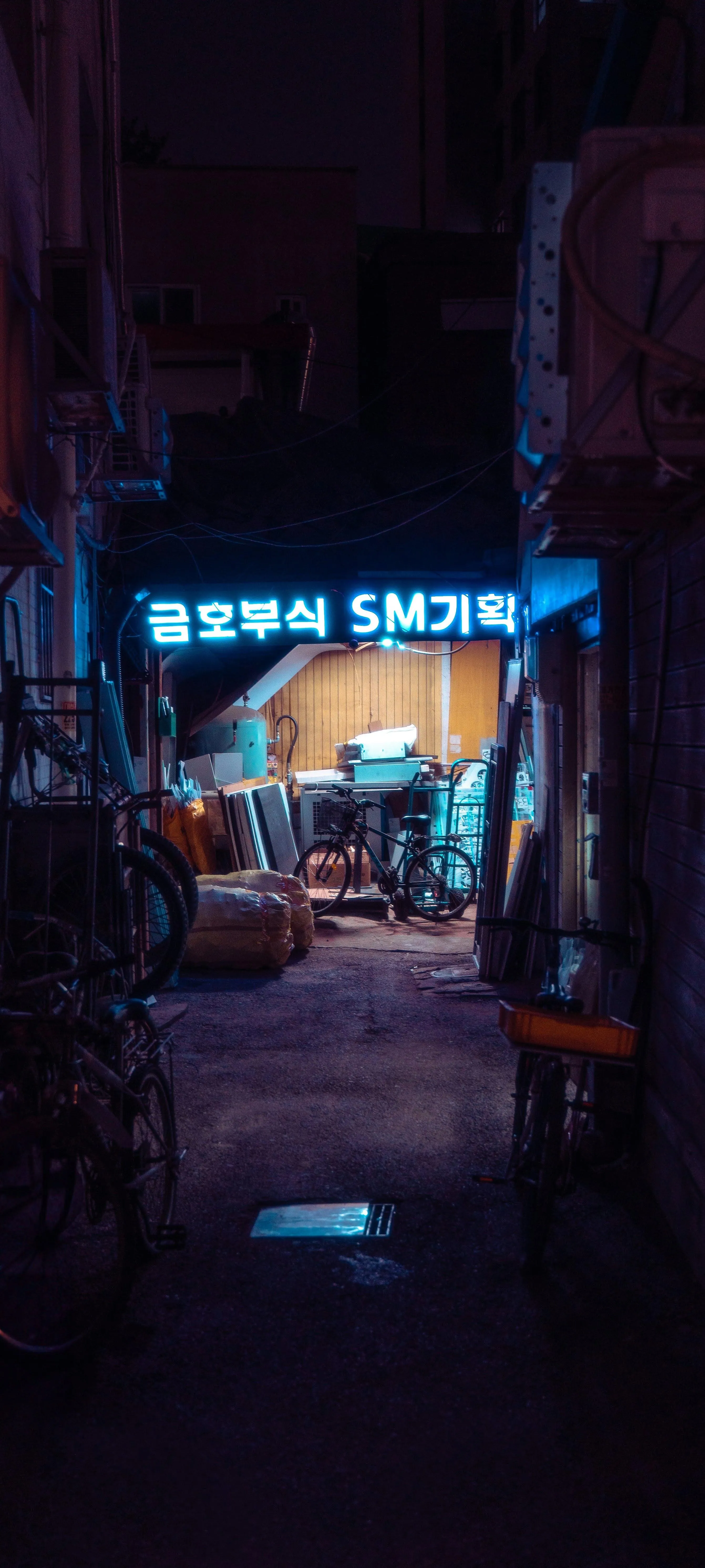 Dark Neon Lit Alleyway with Bright Blue Signs at Night