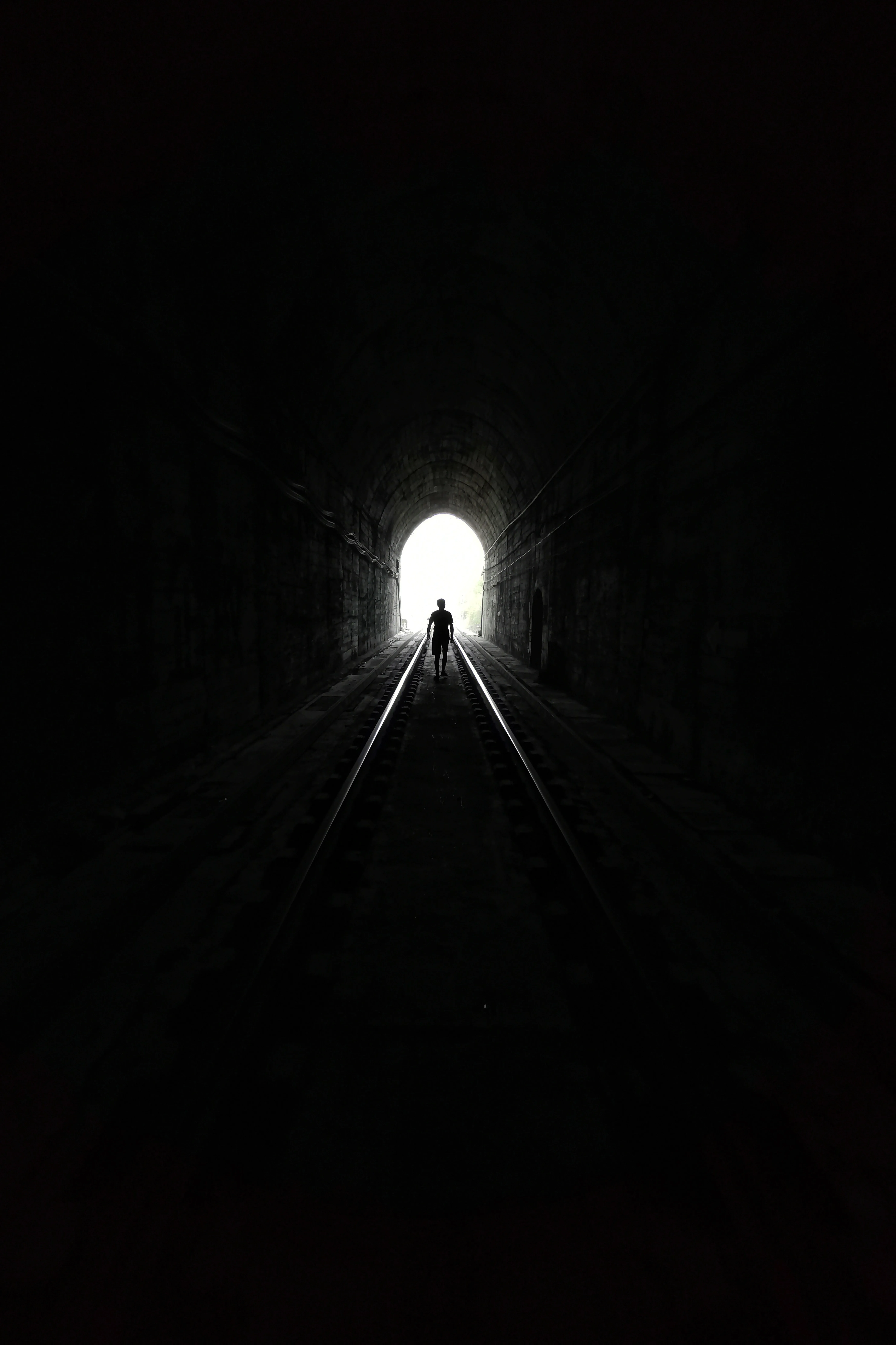 Dark Tunnel Leading to Bright Light End View Wallpaper