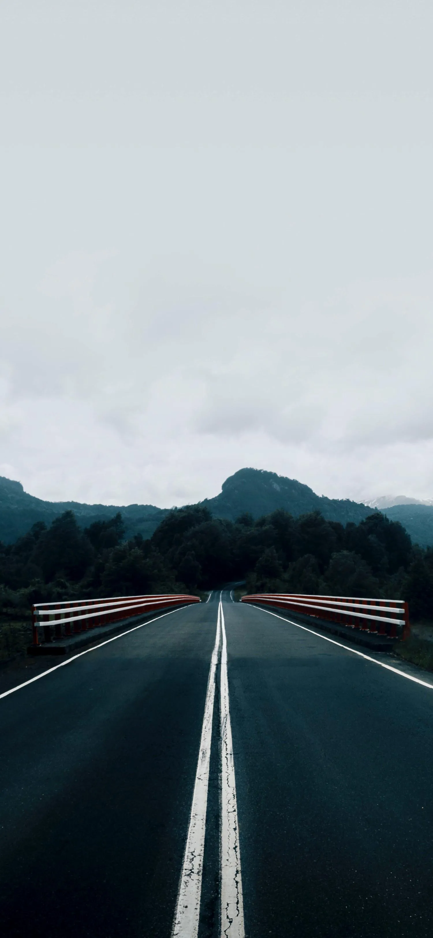 Desert Highway Leading to Mountains Under Cloudy Sky