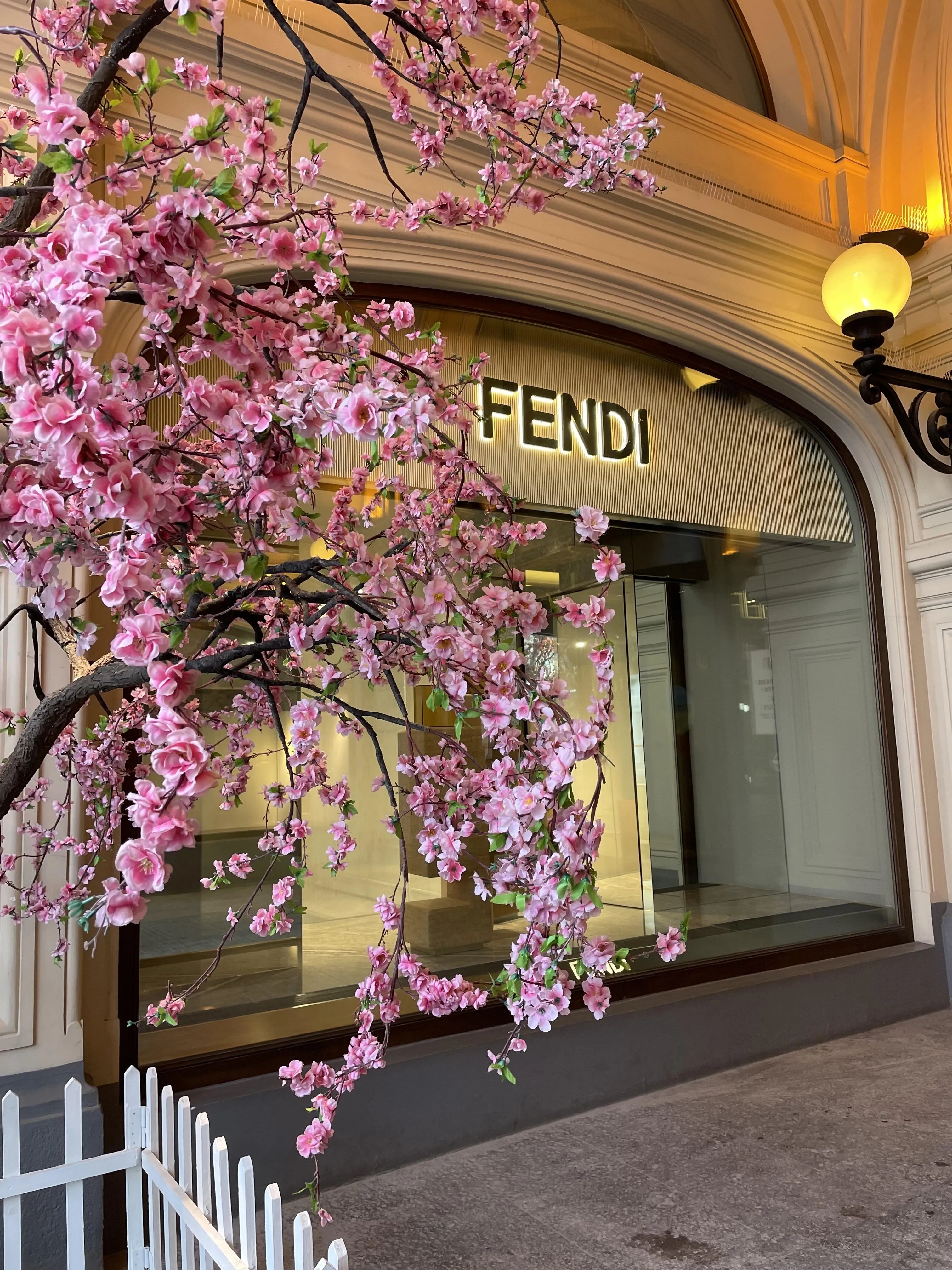 Elegant City Storefront with Pink Flowering Tree Wallpaper