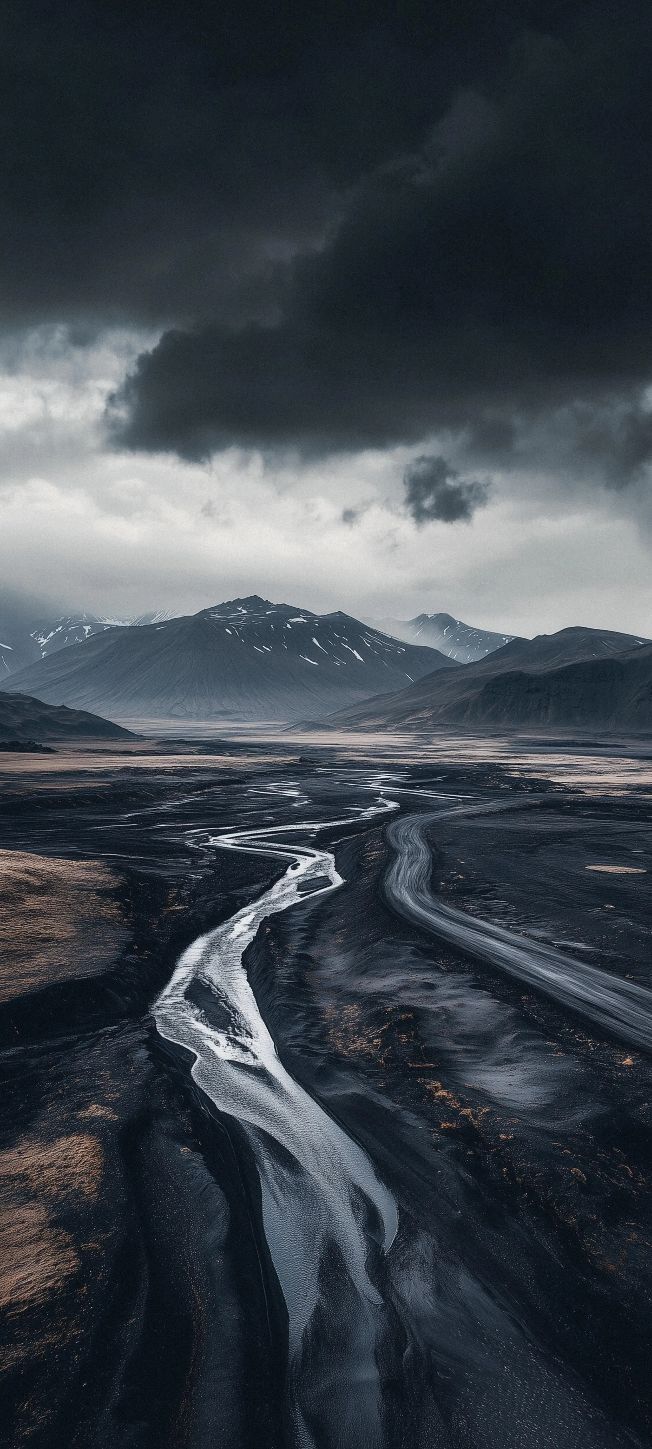 Empty Highway Through Dark Mountainous Terrain Wallpaper