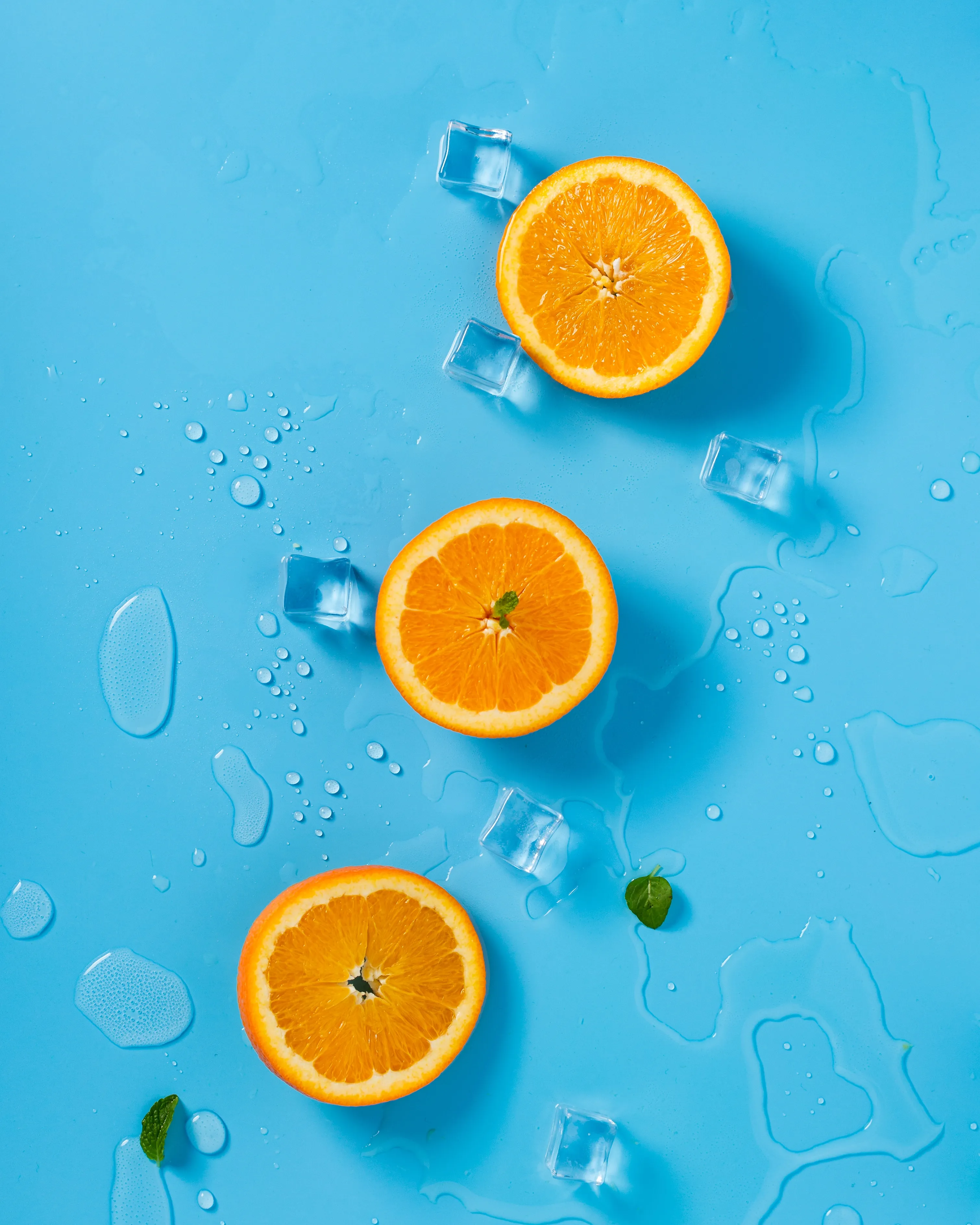 Fresh Orange Slices Floating on Blue Water Wallpaper