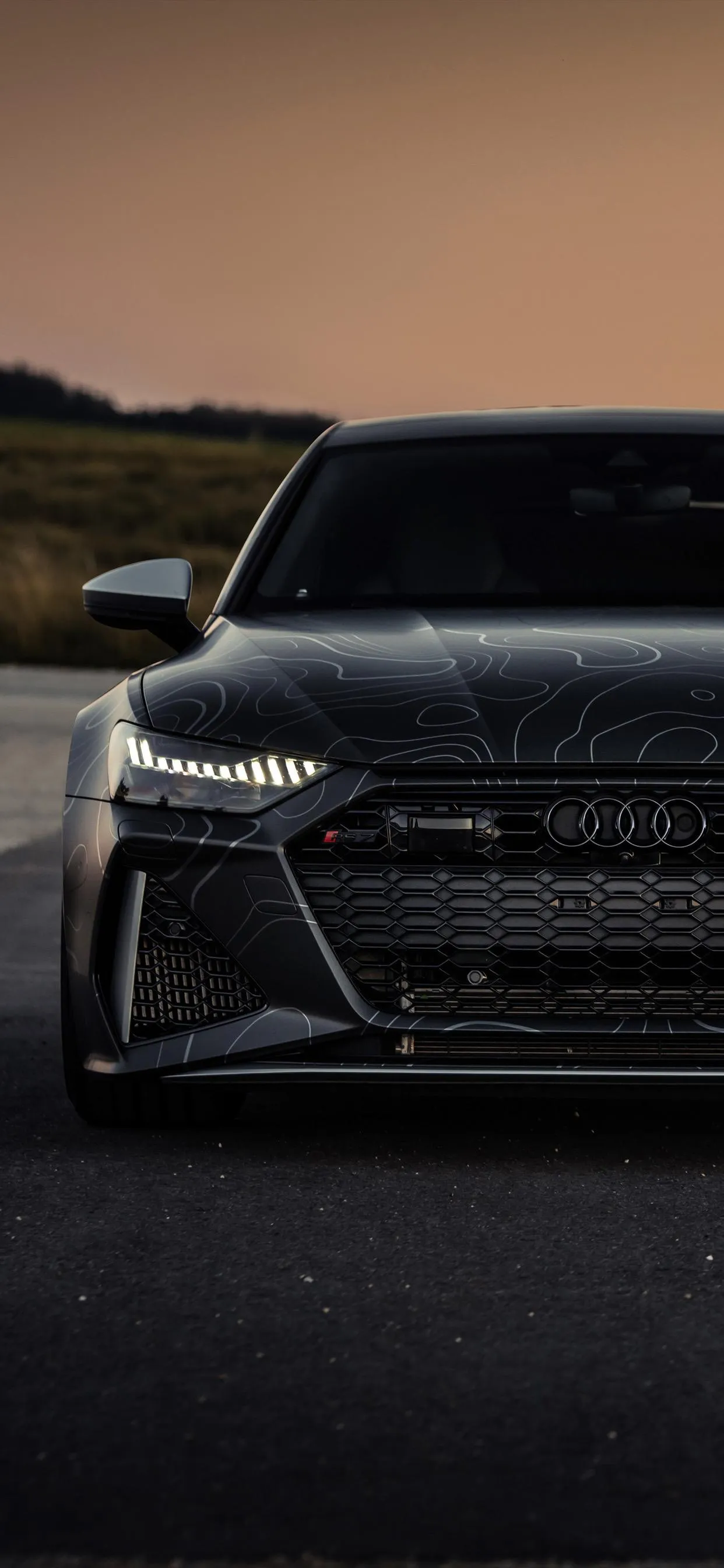 Front View of Luxury Sedan on Desert Road at Sunset