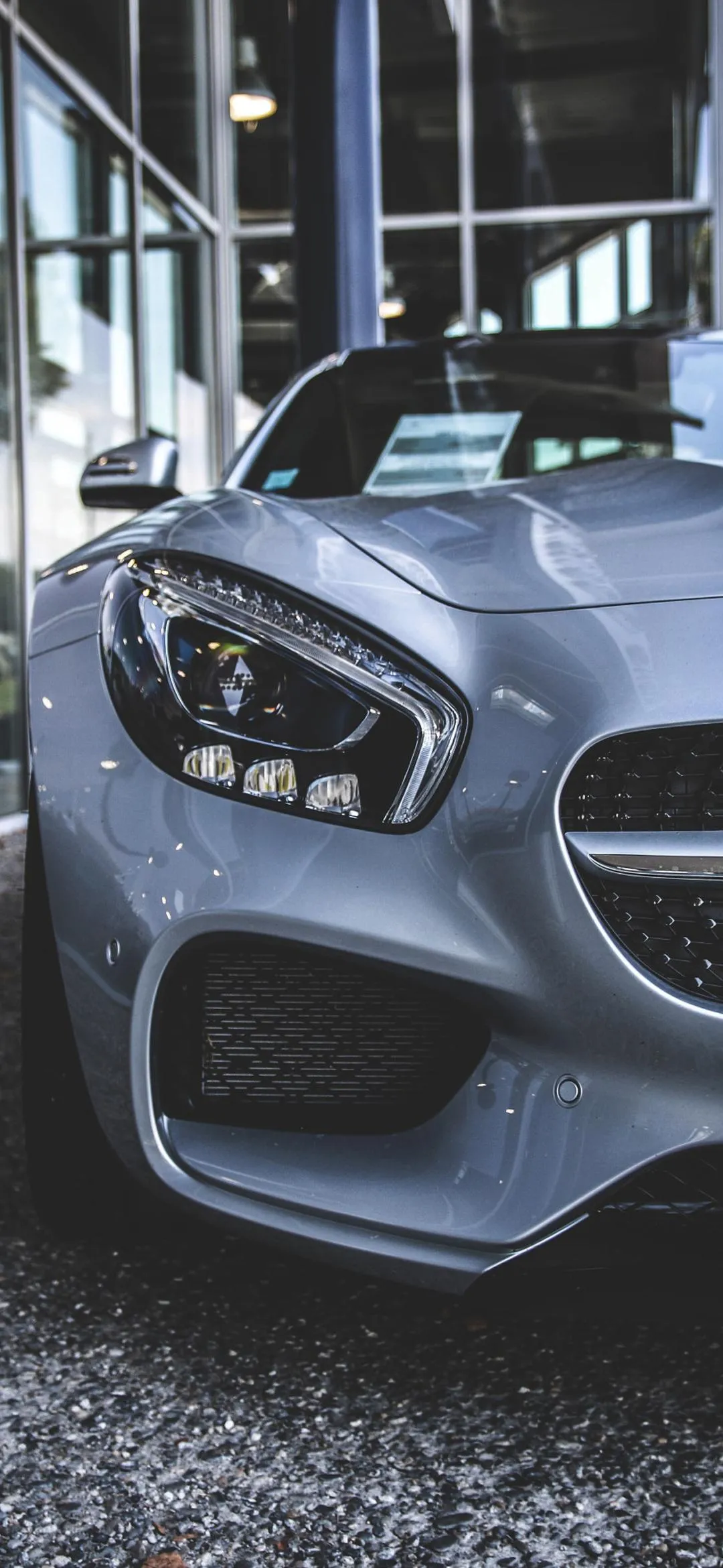 Front View Of Silver Car Parked On Road With Urban Details