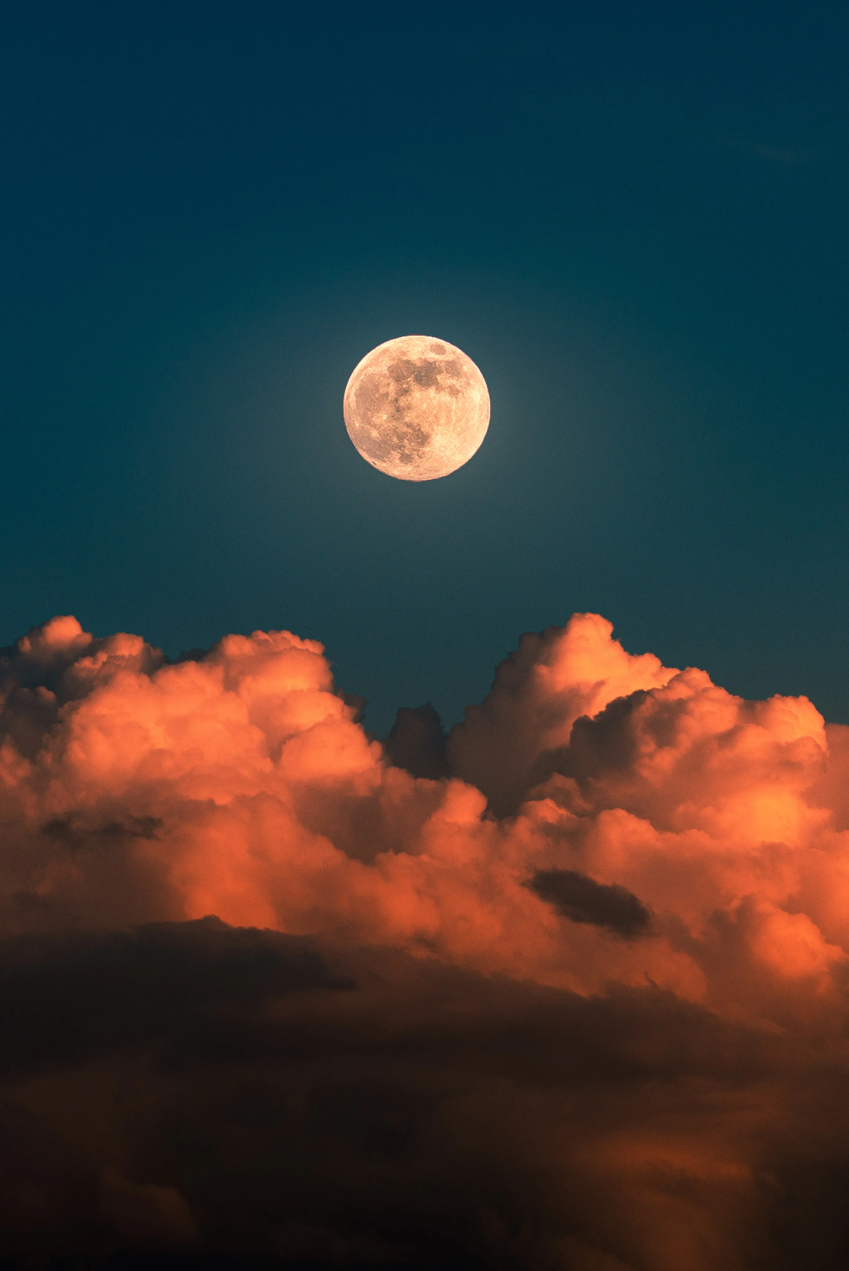 Full Moon Rising Above Vibrant Orange Clouds Wallpaper