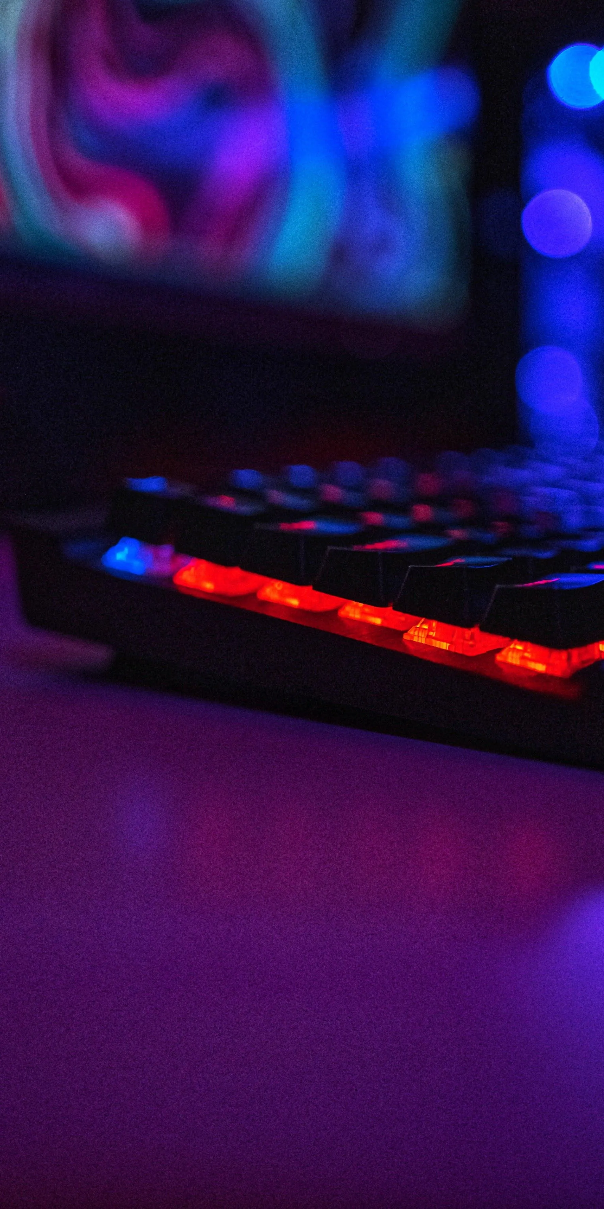 Gaming Keyboard with Neon Lighting in Dark Room Wallpaper