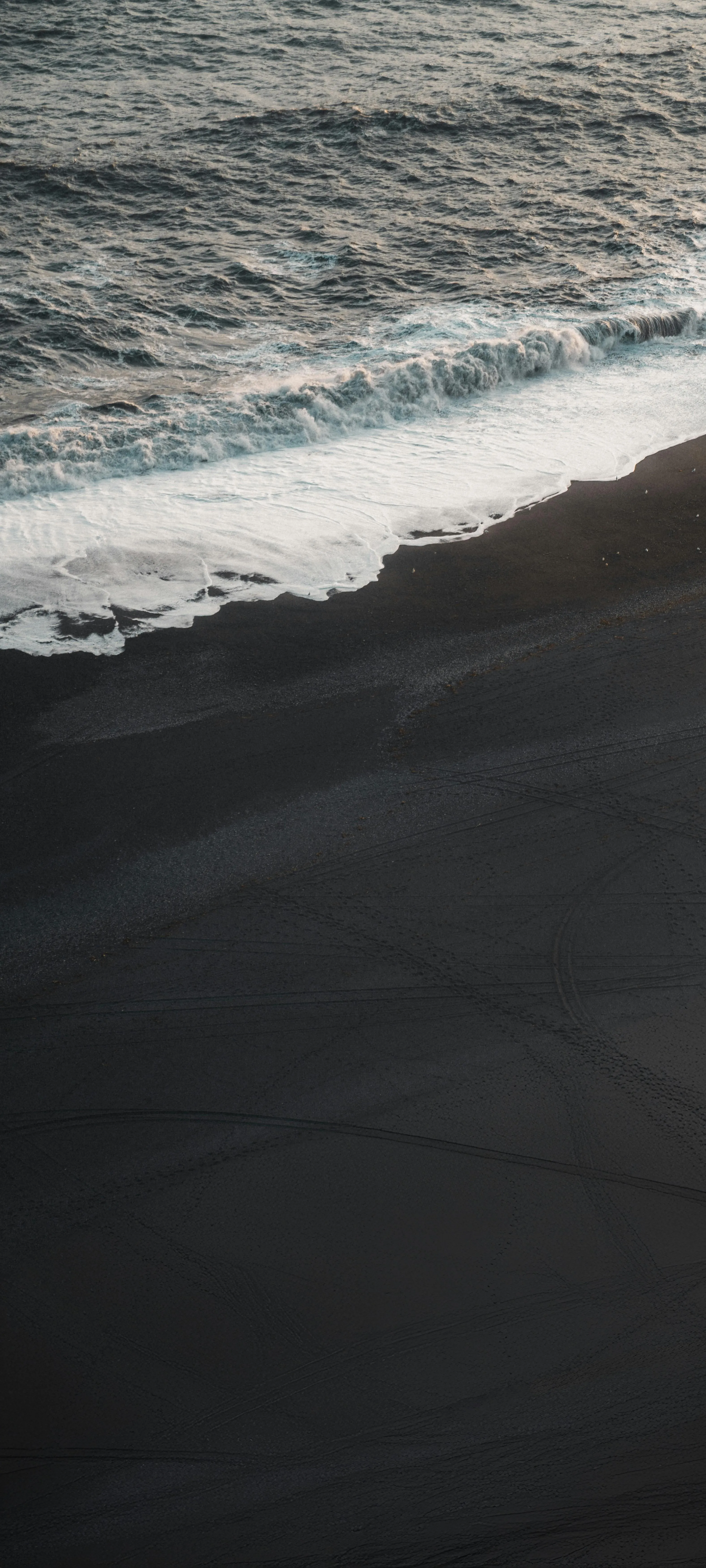 Gentle Ocean Waves Rolling Onto Sandy Shore Wallpaper