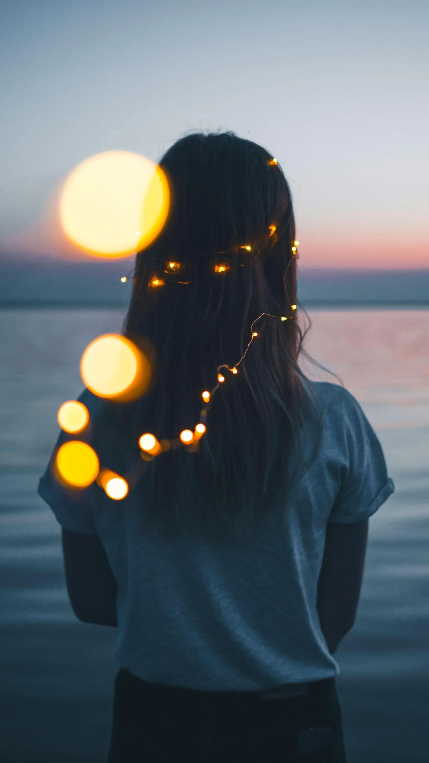 Girl Looking at Sunset With Warm Light Bokeh Wallpaper