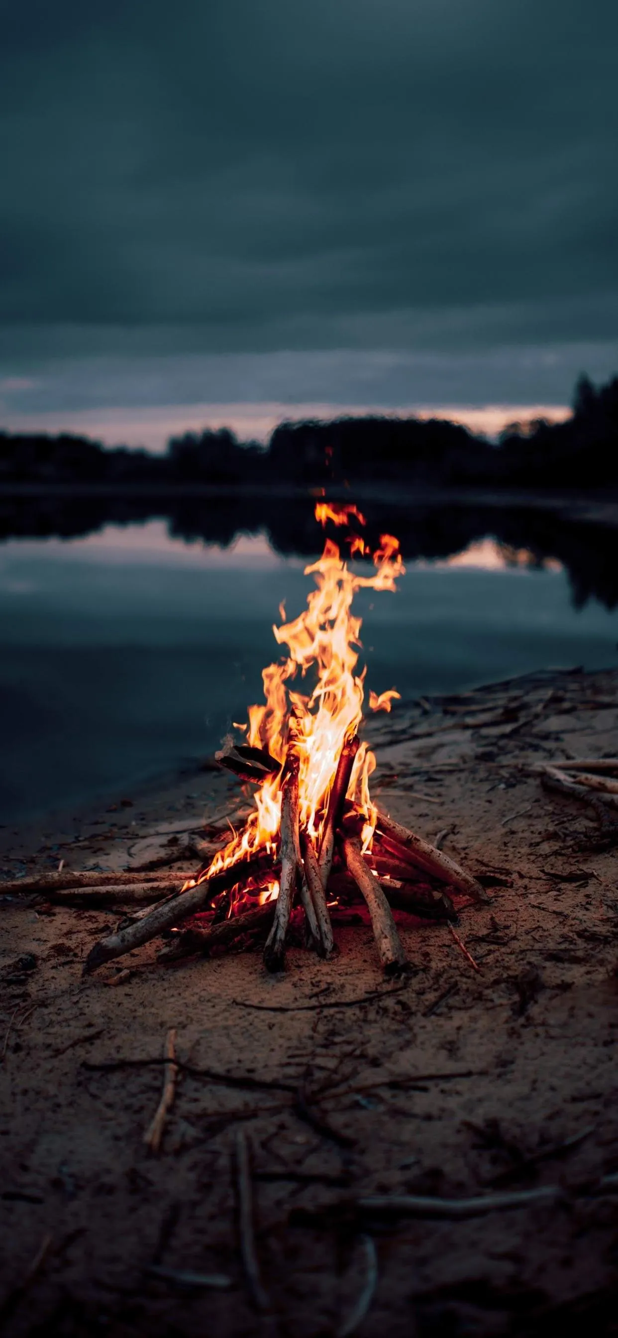 Glowing Campfire near Lake at Peaceful Sunset Wallpaper