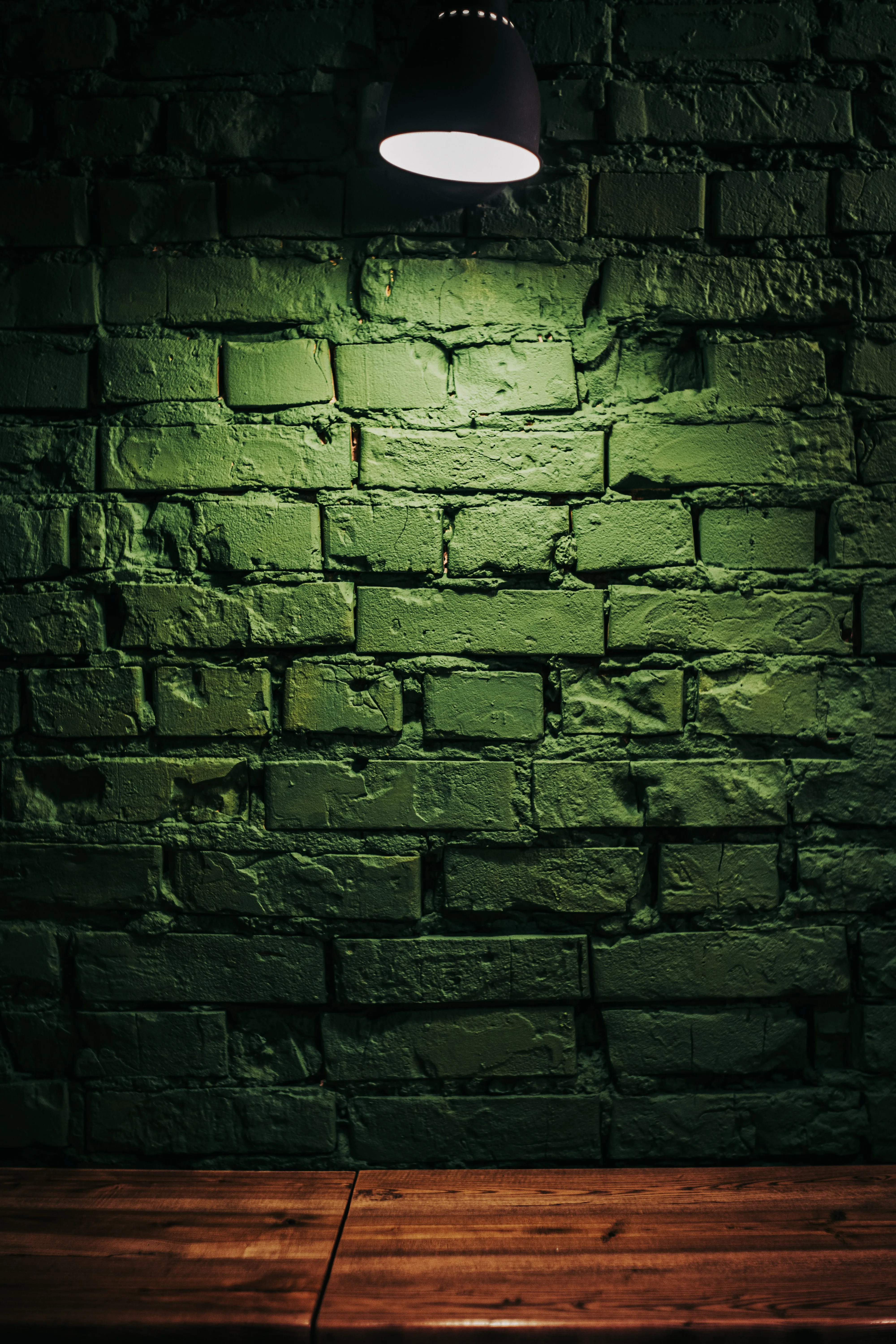 Green Brick Wall Lit by Warm Indoor Light Wallpaper