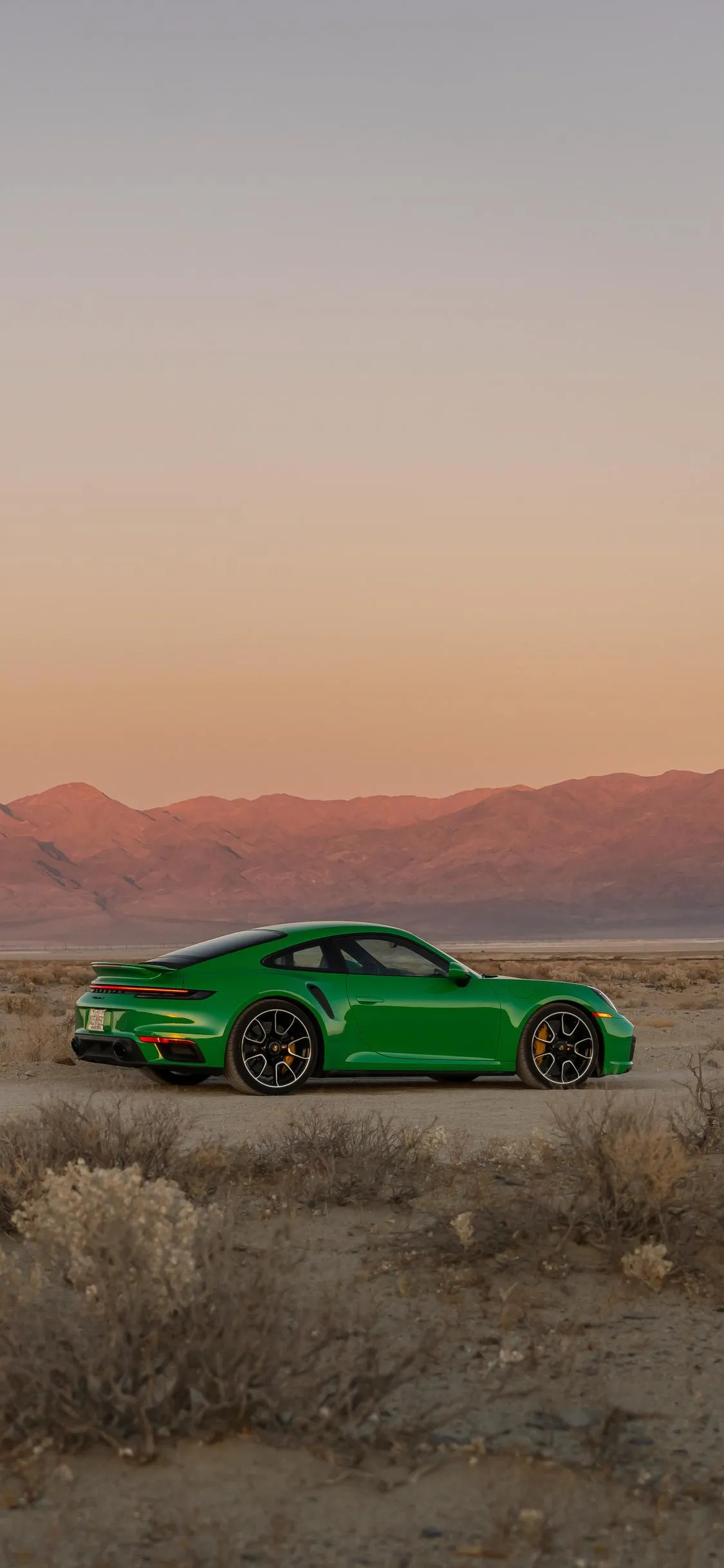 Green Sports Car in Desert Sunset Background Wallpaper